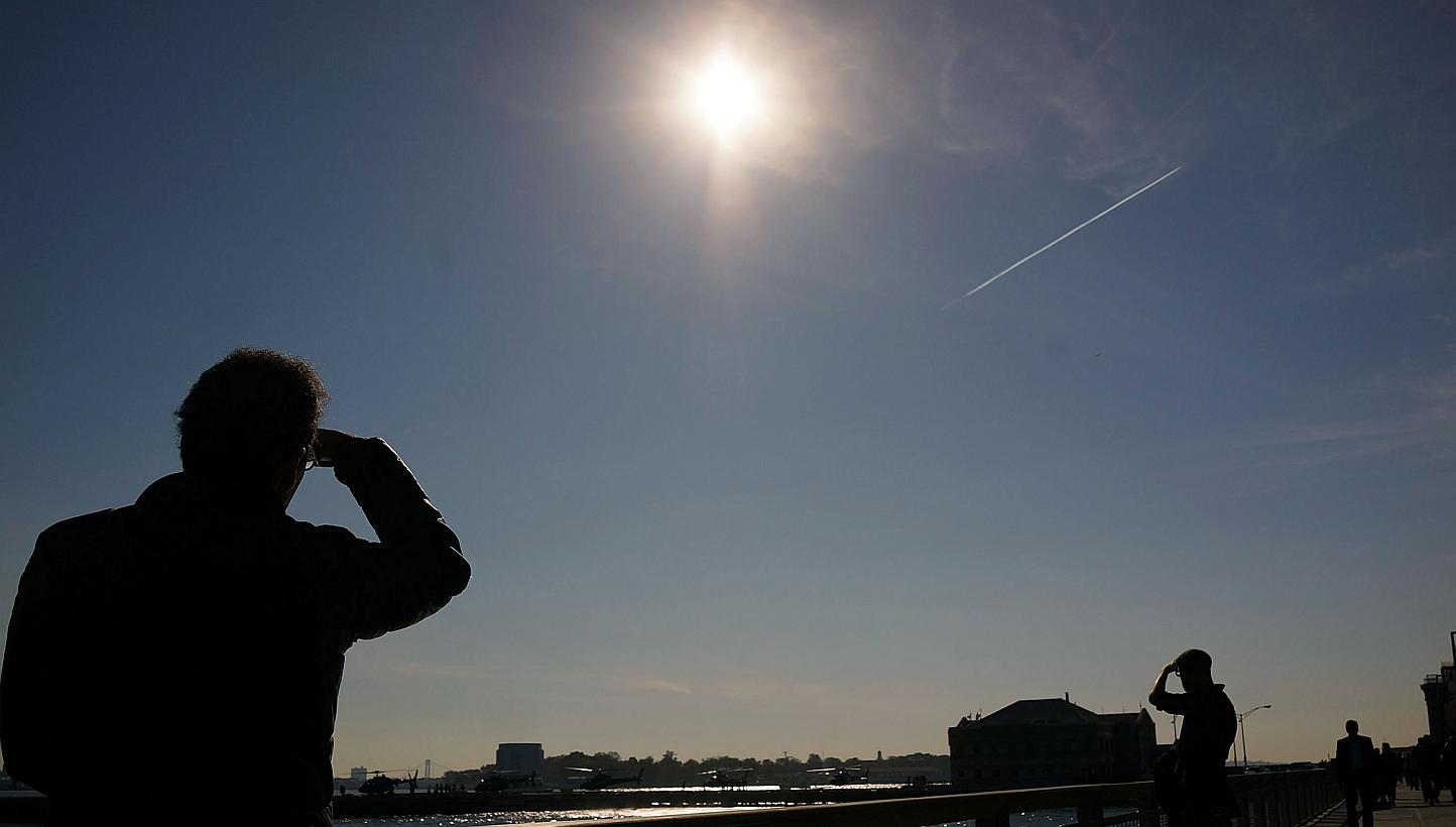 People relax along the water in lower Manhattan on a sunny afternoon which saw temperatures hit unseasonal highs on Nov 10, 2014 in New York City. Last year was the hottest in modern history, according a report by US government scientists on Fri