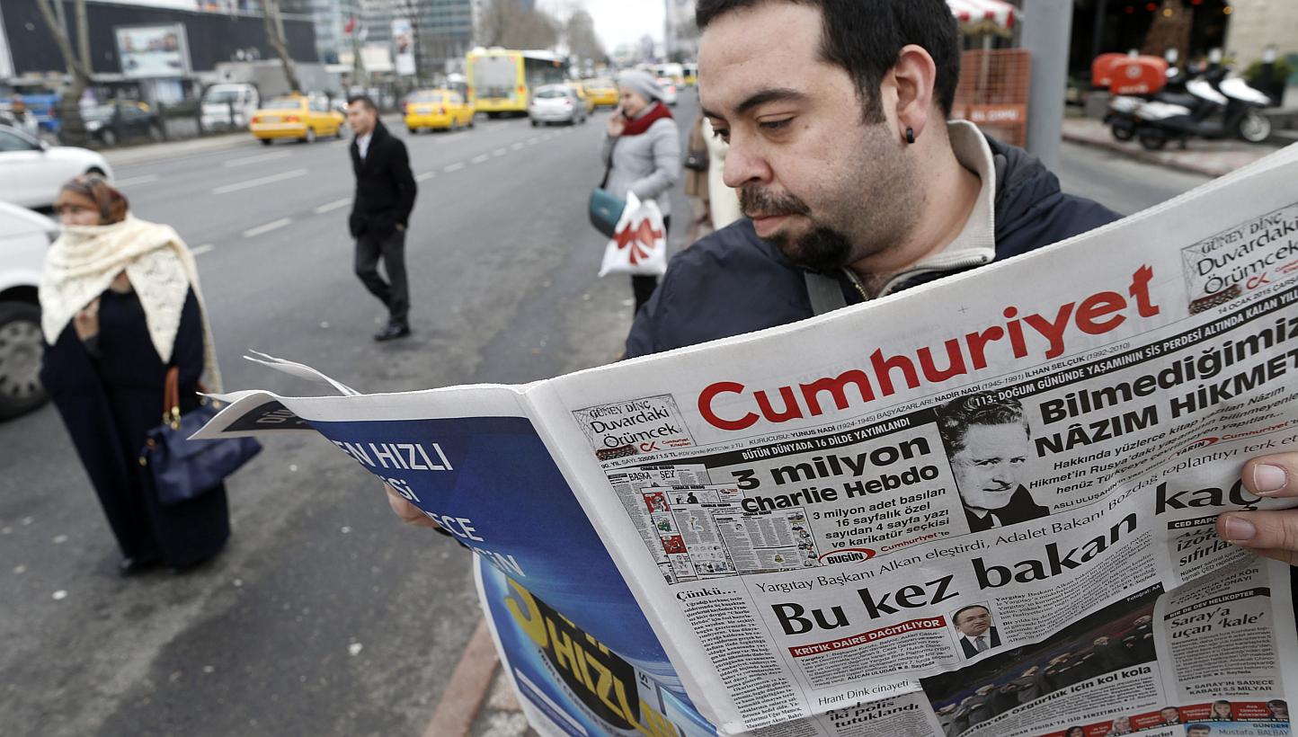 A Turkish man reads an edition of the Cumhuriyet daily newspaper featuring&nbsp;a four-page Charlie Hebdo pull-out translated into Turkish including cartoons satirising Nigerian Islamist group Boko Haram and Islamic State in Iraq and Syria&nbsp;in Is