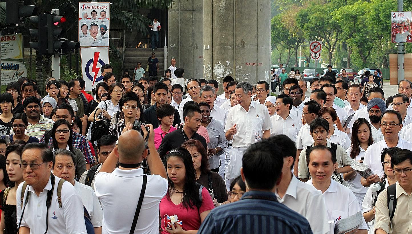 Prime Minister Lee Hsien Loong talking to commuters on his way to Ang Mo Kio MRT station on May 4, 2011. -- PHOTO: ST FILE