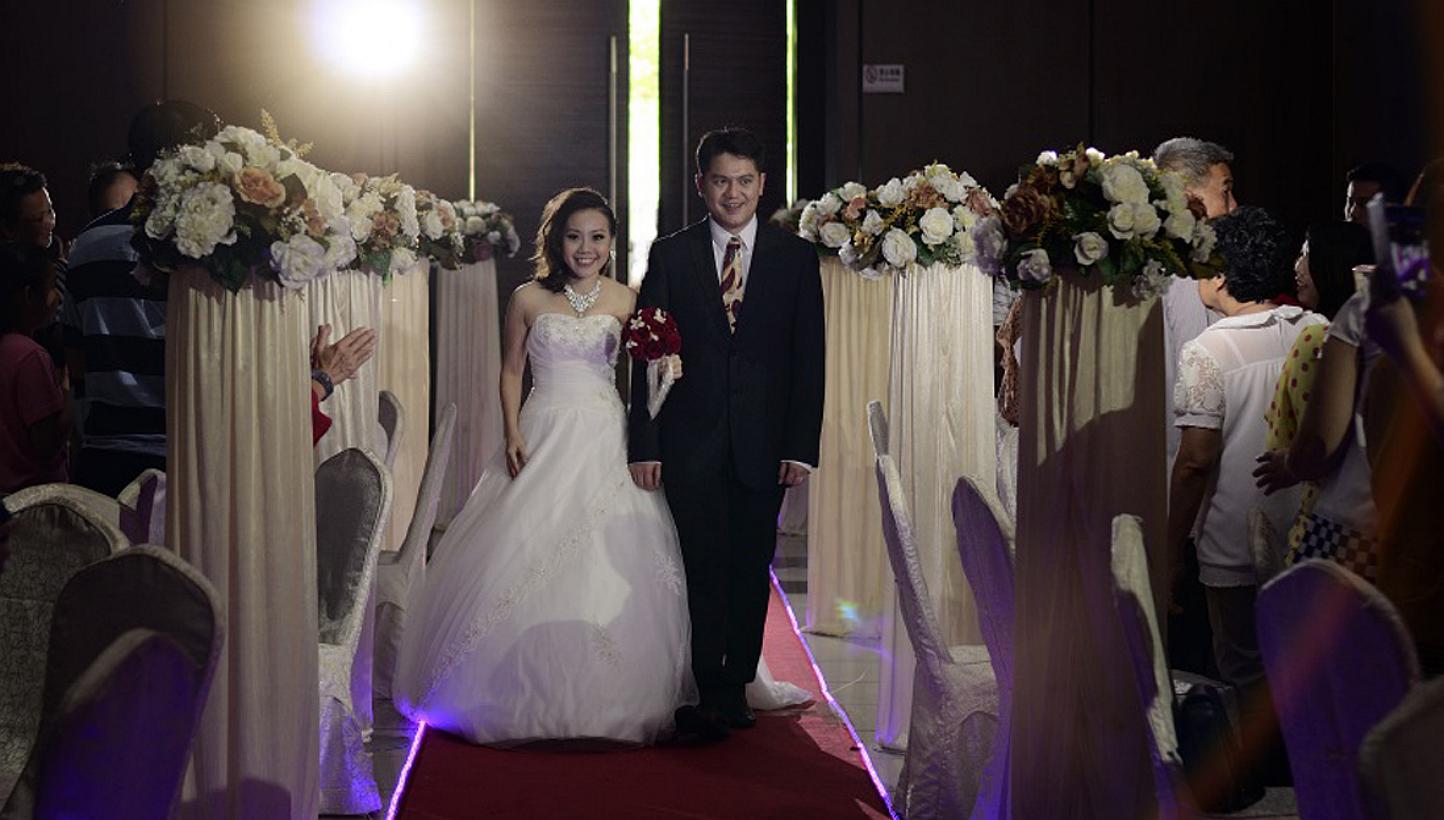 Newlyweds Gideon Tan and Rebecca Goh (both above) held their wedding at Pekin Restoran Johor Jaya restaurant in Johor Baru and chartered two buses to the tune of $1,400 to ferry their family and friends across the Causeway. -- PHOTO: COURTESY OF