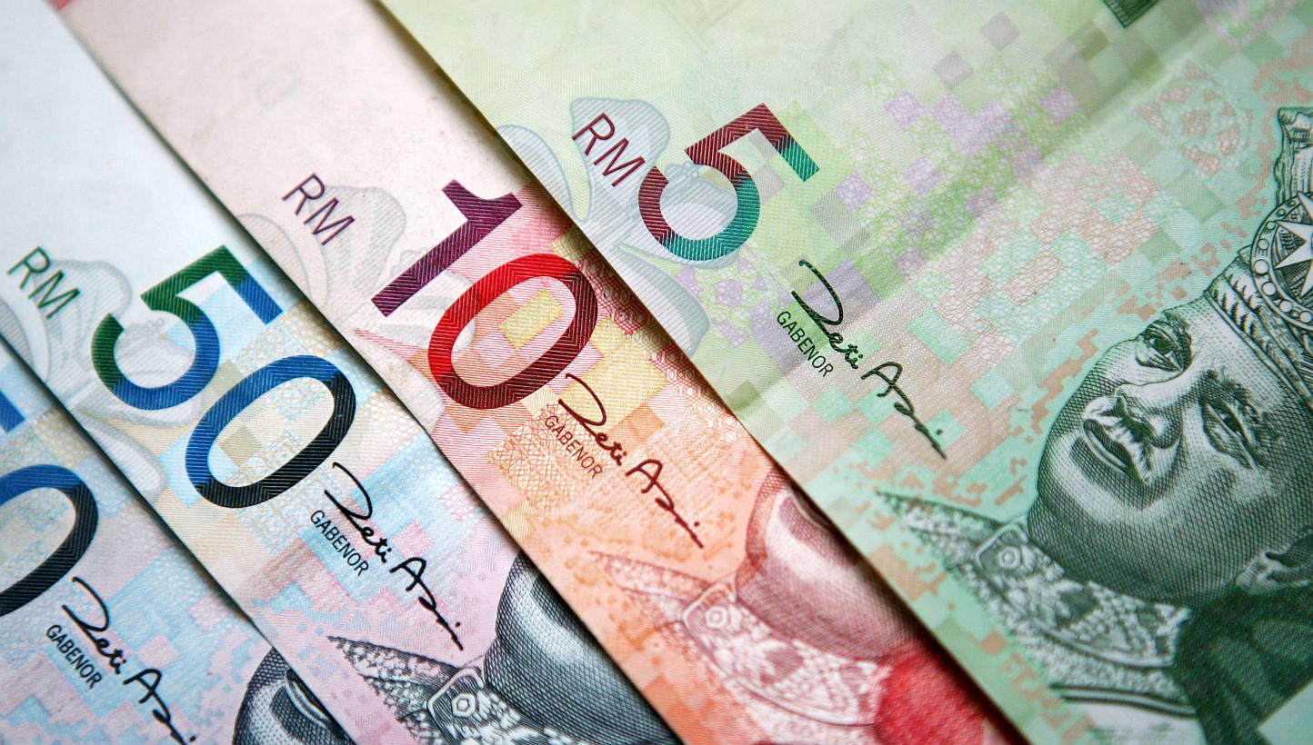 Malaysia's ringgit extended a three-month loss to almost 10 per cent, the worst in Asia, after the government's increase to the fiscal deficit target prompted Fitch Ratings to warn of a credit-rating downgrade. -- PHOTO: BLOOMBERG