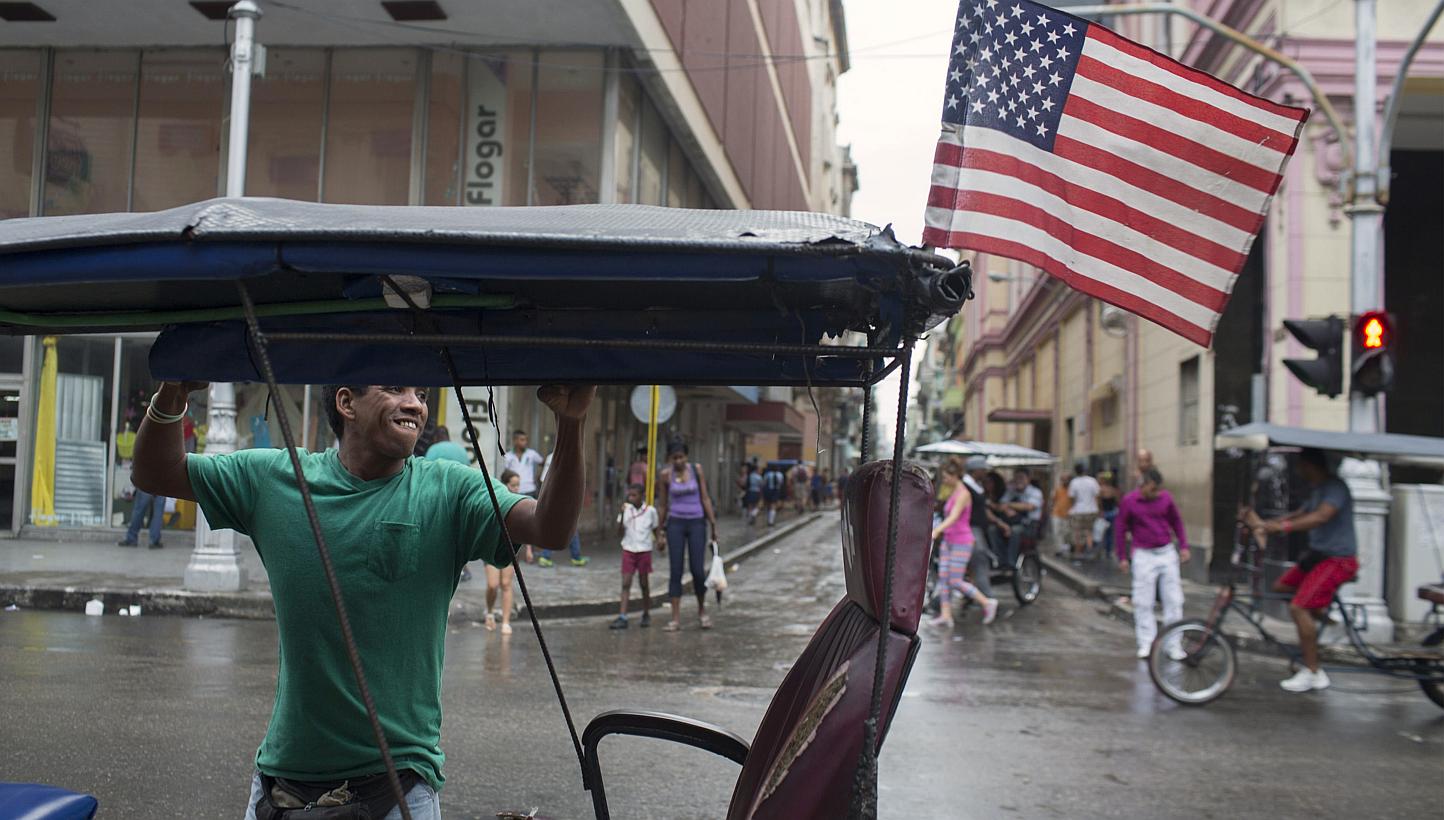 Bici taxi driver Yosvani Gomes, 39, lifts the curtains of his vehicle after a rain in downtown Havana Jan 20, 2015. The United States and Cuba opened two days of historic talks in Havana on Wednesday to end decades of Cold War-era animosity and