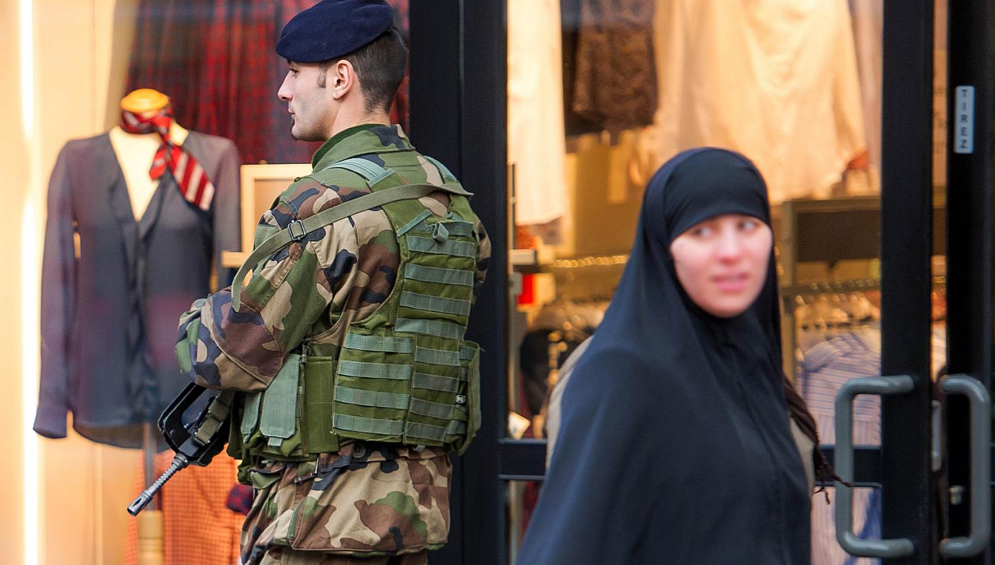 A veiled woman walks past a soldier patroling in a street of Roubaix, northern France, on Jan 13, 2015, as France announced an unprecedented deployment of thousands of troops and police to bolster security at "sensitive" sites. -- PHOTO: AFP