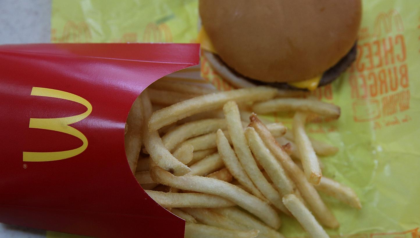 A McDonald's cheeseburger and fries are displayed on a table at a McDonald's restaurant on Dec 8, 2014 in Novato, California. -- PHOTO: AFP