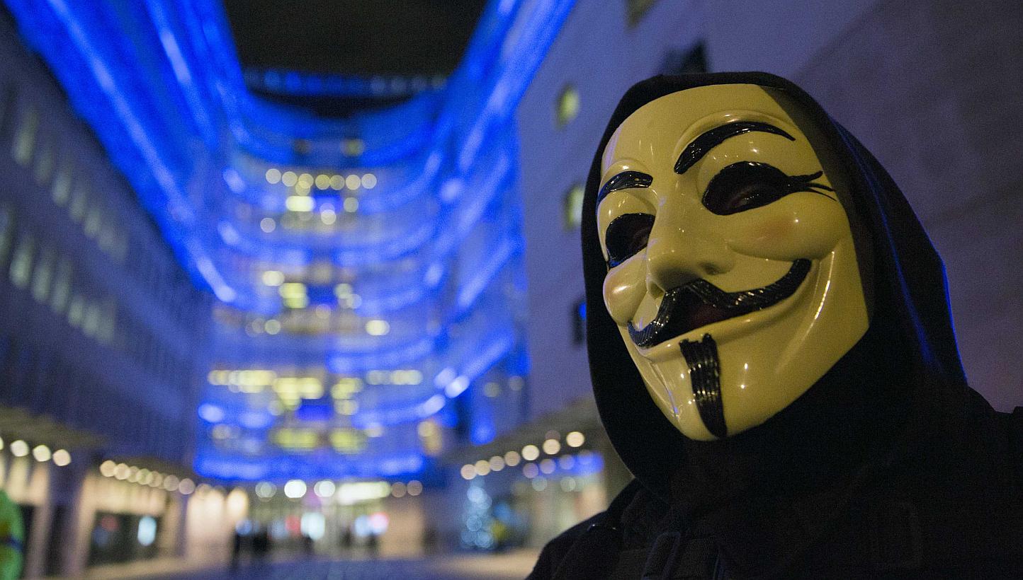 A supporter of the activist group Anonymous wearing a mask associated with the group on Dec 23, 2014. A journalist also known as an informal spokesman for the hacker group Anonymous was sentenced to five years in prison on Thursday in a case which ra