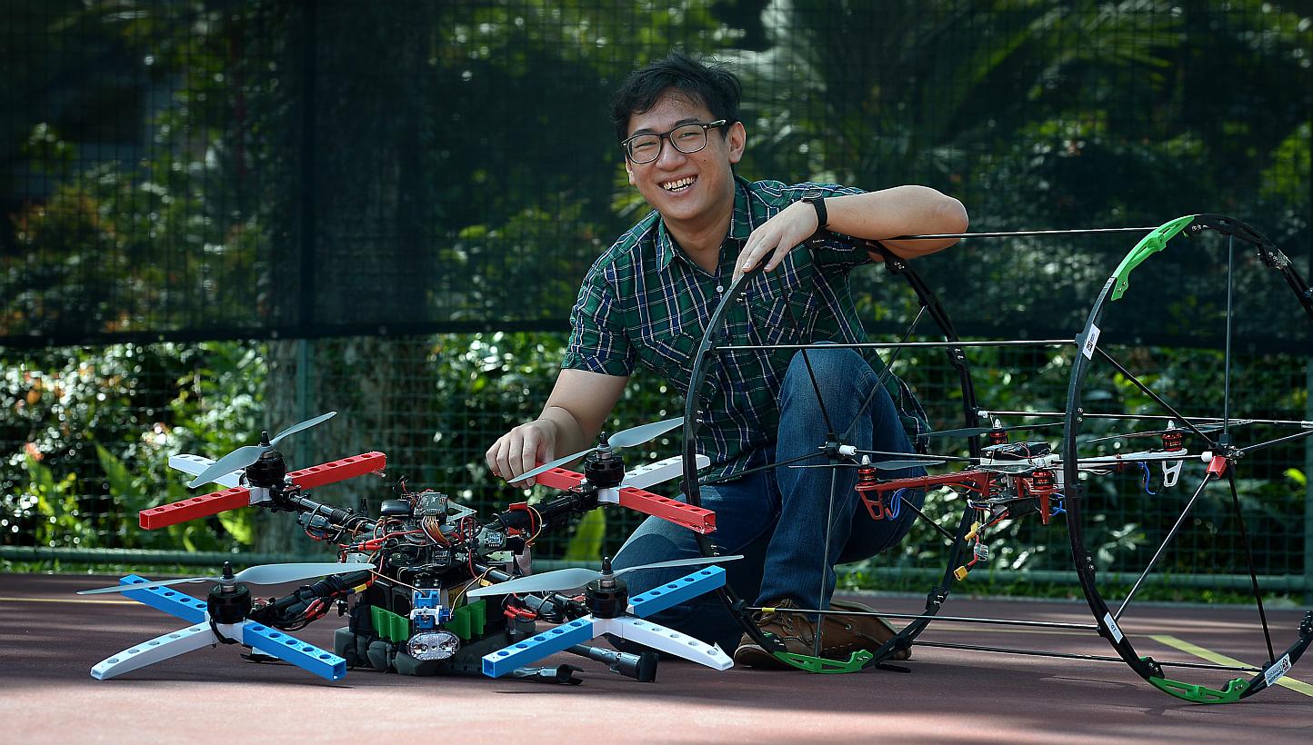 NUIS student Jonathan Chua, 25, with two variations of the multi-purpose quadcopter developed by his team. When a roll cage (right) is snapped on, it can roll on the ground and enter buildings to give aid or reconnoitre.