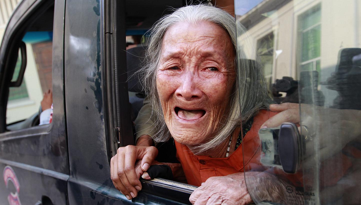 Cambodian woman Nget Khun, 75, crying at a police van window at the appeals court in Phnom Penh, Cambodia on Jan 26, 2015.&nbsp;-- PHOTO: EPA