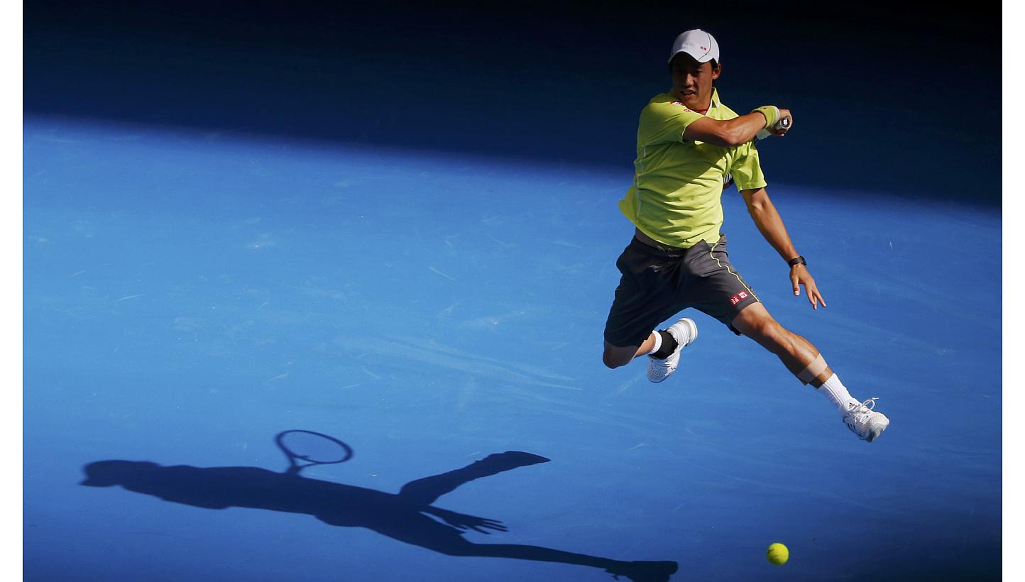 Kei Nishikori of Japan casts a shadow as he hits a return to David Ferrer of Spain during their men's singles fourth round match at the Australian Open 2015 tennis tournament in Melbourne on Jan 26, 2015. -- PHOTO: REUTERS