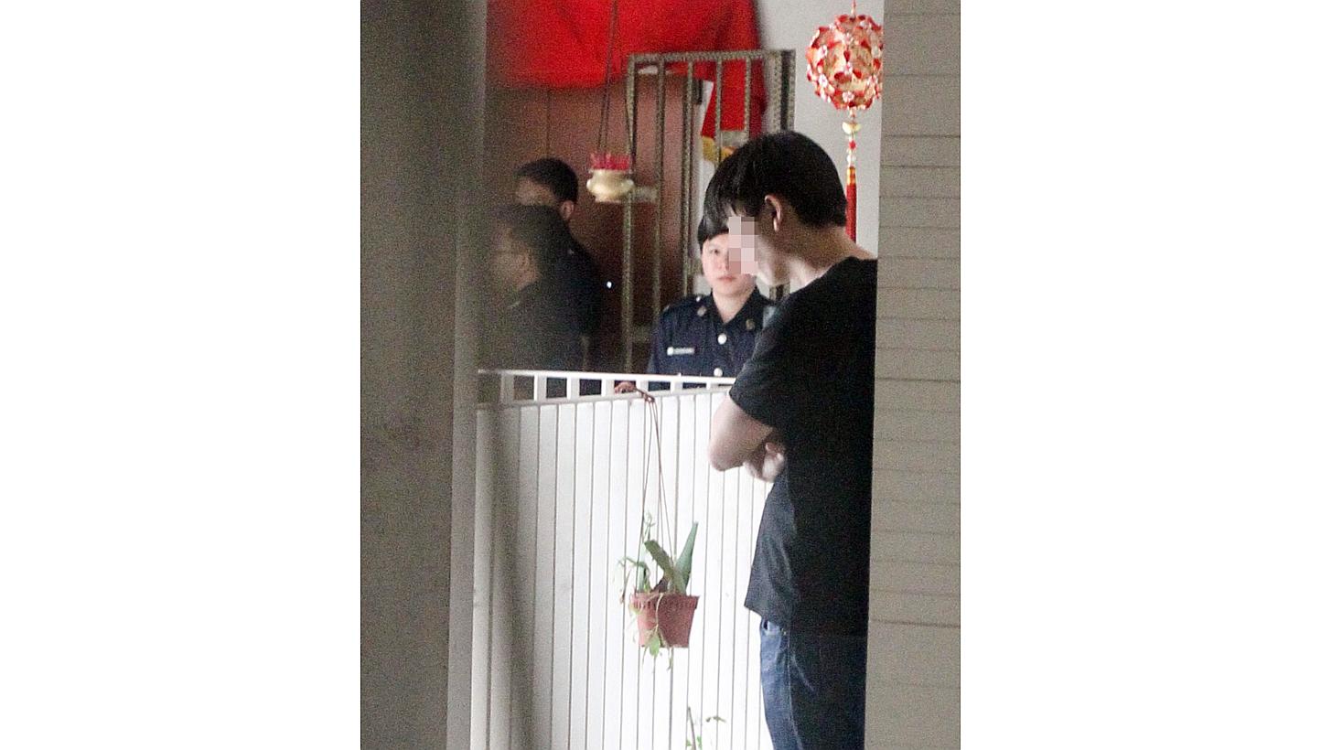 Police officers outside the house where a man was killed in a freak accident after his throat was cut by glass from a broken door when he fell in the shower. -- PHOTO: SHIN MIN DAILY&nbsp;