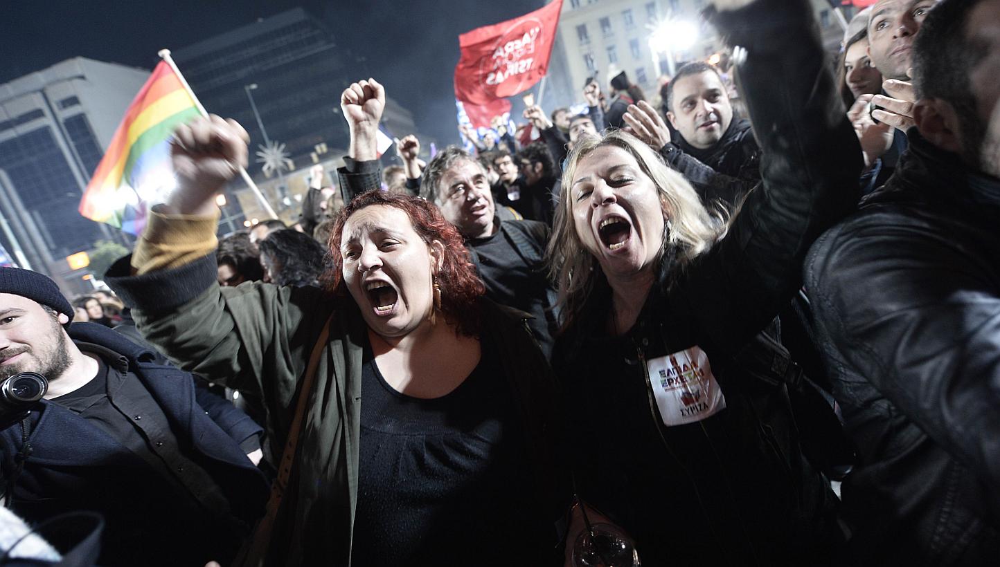 Anti-austerity Syriza party supporters celebrating as leader Alexis Tsipras speaks folllowing victory in the election in Athens on Jan 25, 2015. -- PHOTO: AFP