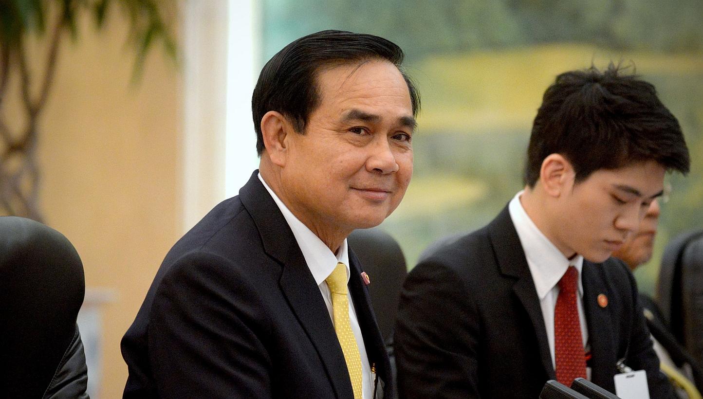 Thailand's Prime Minister Prayuth Chan-ocha (centre) listens as he meets with China's President Xi Jinping (not pictured) at the Great Hall of the People in Beijing on Dec 23, 2014. -- PHOTO: REUTERS