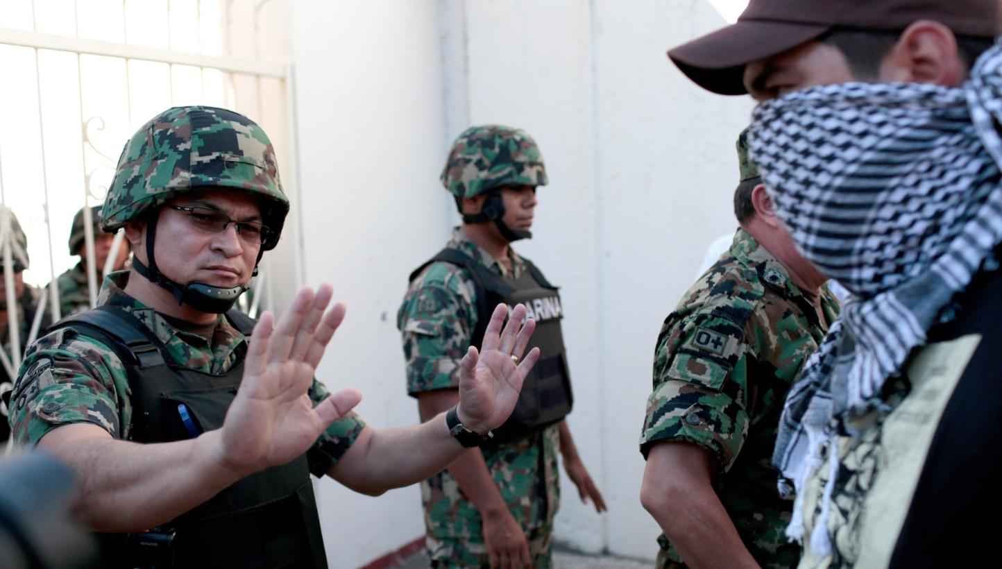 Mexican soldiers block the way to masked people during a protest demanding justice and clarification of the disappearance of 43 students from Ayotzinapa, on Jan 12, 2015, at the naval base in Acapulco, Guerrero State, Mexico. From Tuesday, Jan 27, 20