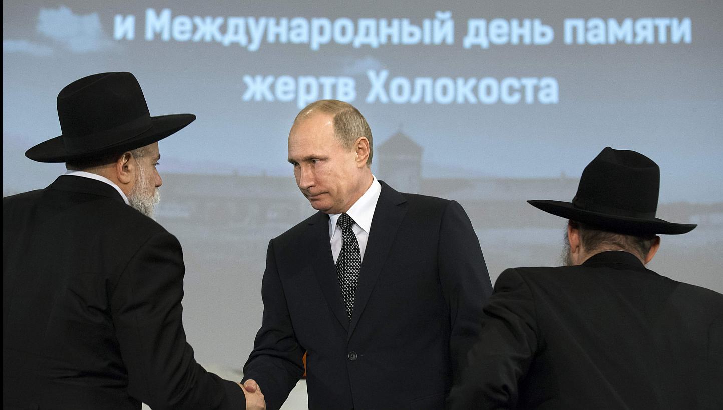 Russian President Vladimir Putin (centre) greets head of the Federation of Jewish Communities of Russia Alexander Boroda (left) and Russian Chief Rabbi Berel Lazar during a ceremony marking the 70th anniversary of the liberation of former Nazi German