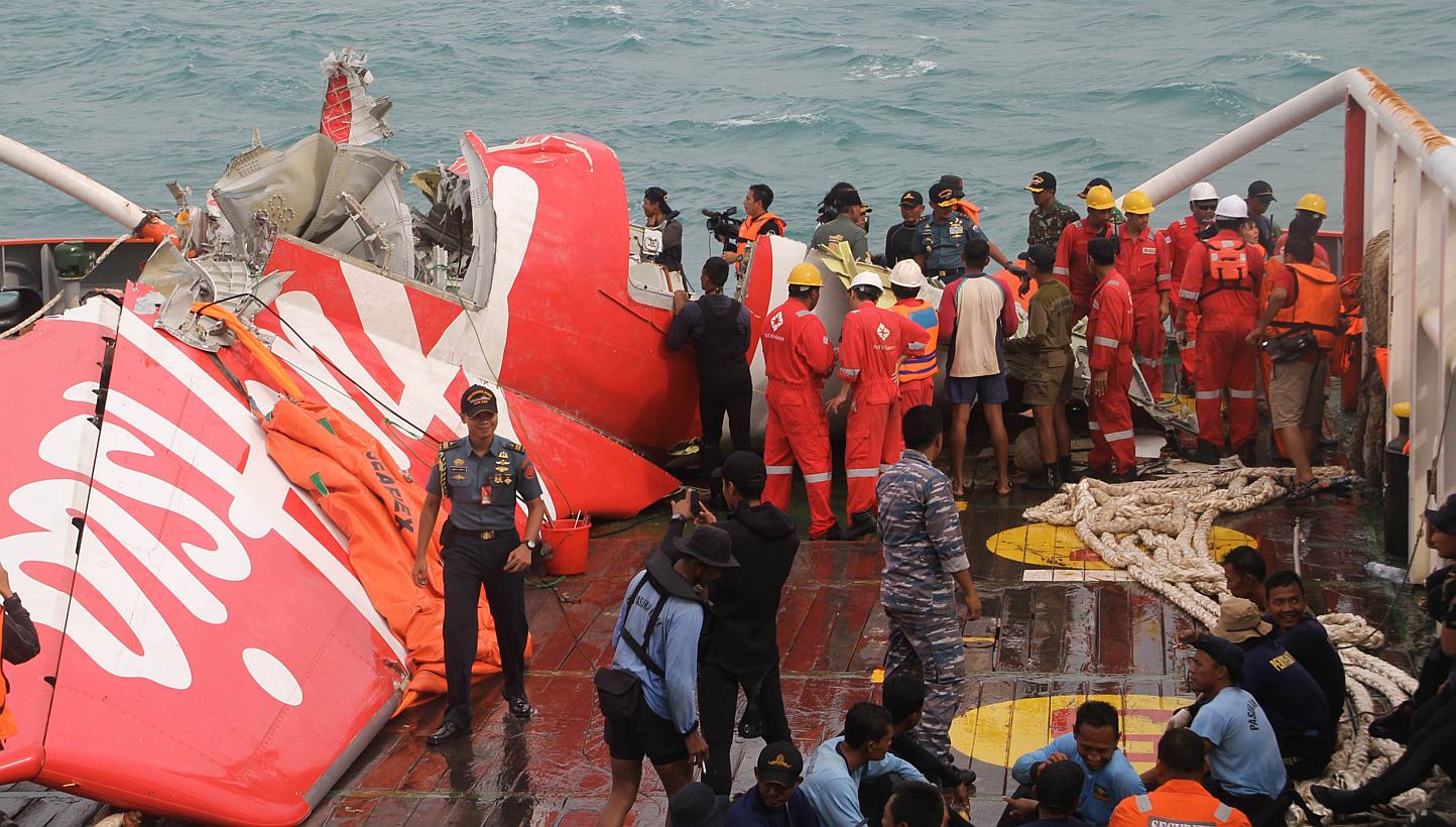 In this Jan 10, 2015 photo, wreckage from AirAsia flight QZ8501 is lifted into a ship at sea south of Borneo island. -- PHOTO: AFP