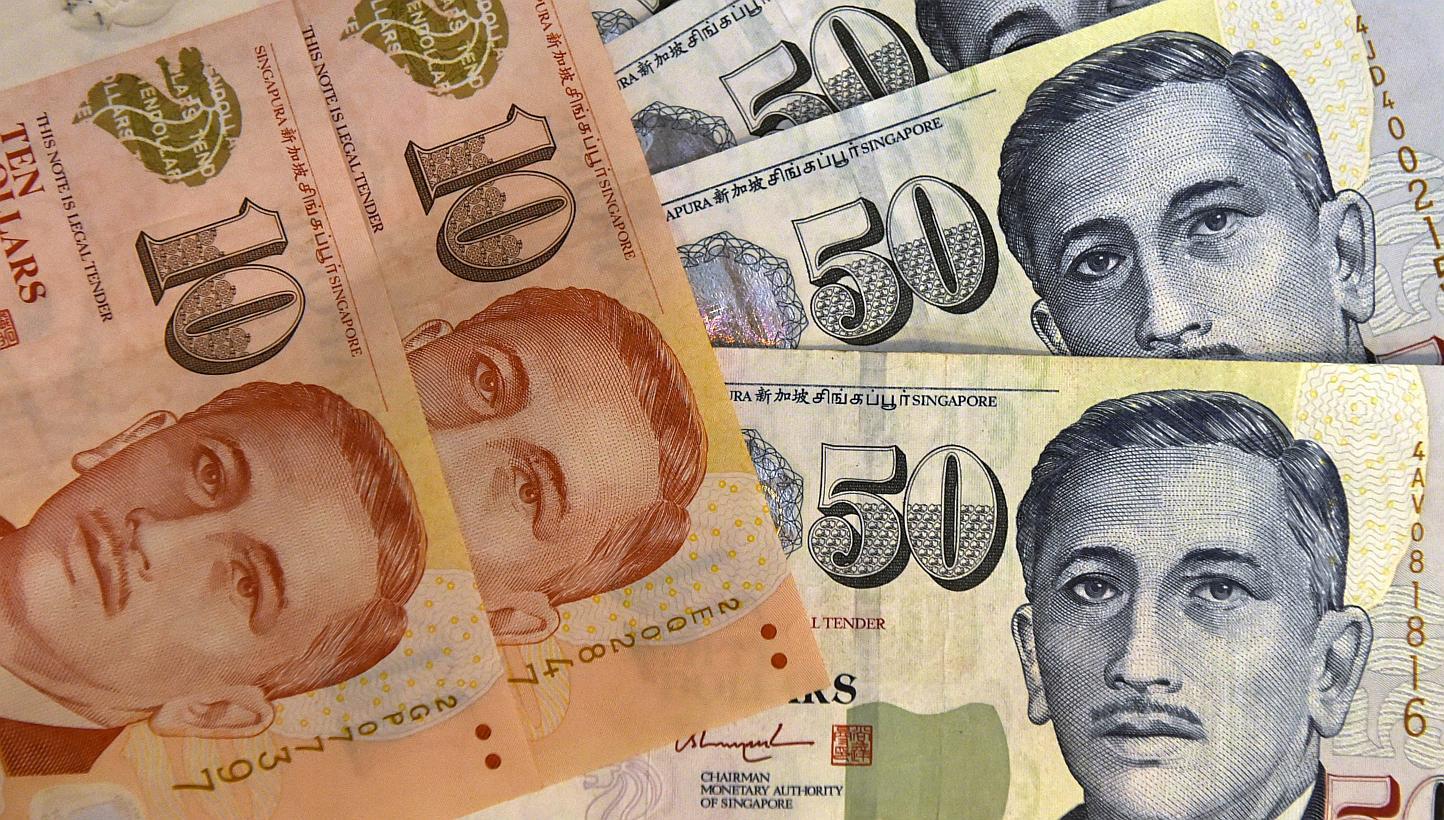 The Singapore dollar on Wednesday hit its weakest in nearly four and a half years, driving losses among emerging Asian currencies, as regional central banks may follow the city-state's unexpected monetary policy easing to tackle deflation. -- PHOTO: