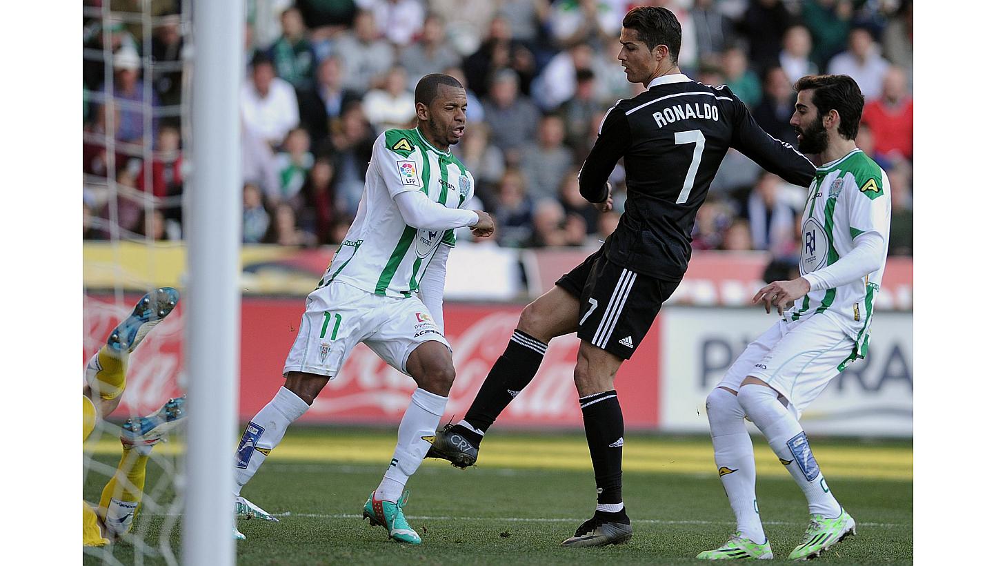 Real Madrid's Portuguese forward Cristiano Ronaldo (right) kicks the leg of Cordoba's Brazilian defender Edimar Fraga, earning him a red card during the Spanish league football match at the Nuevo Arcangel stadium on Jan 24, 2015. -- PHOTO: AFP