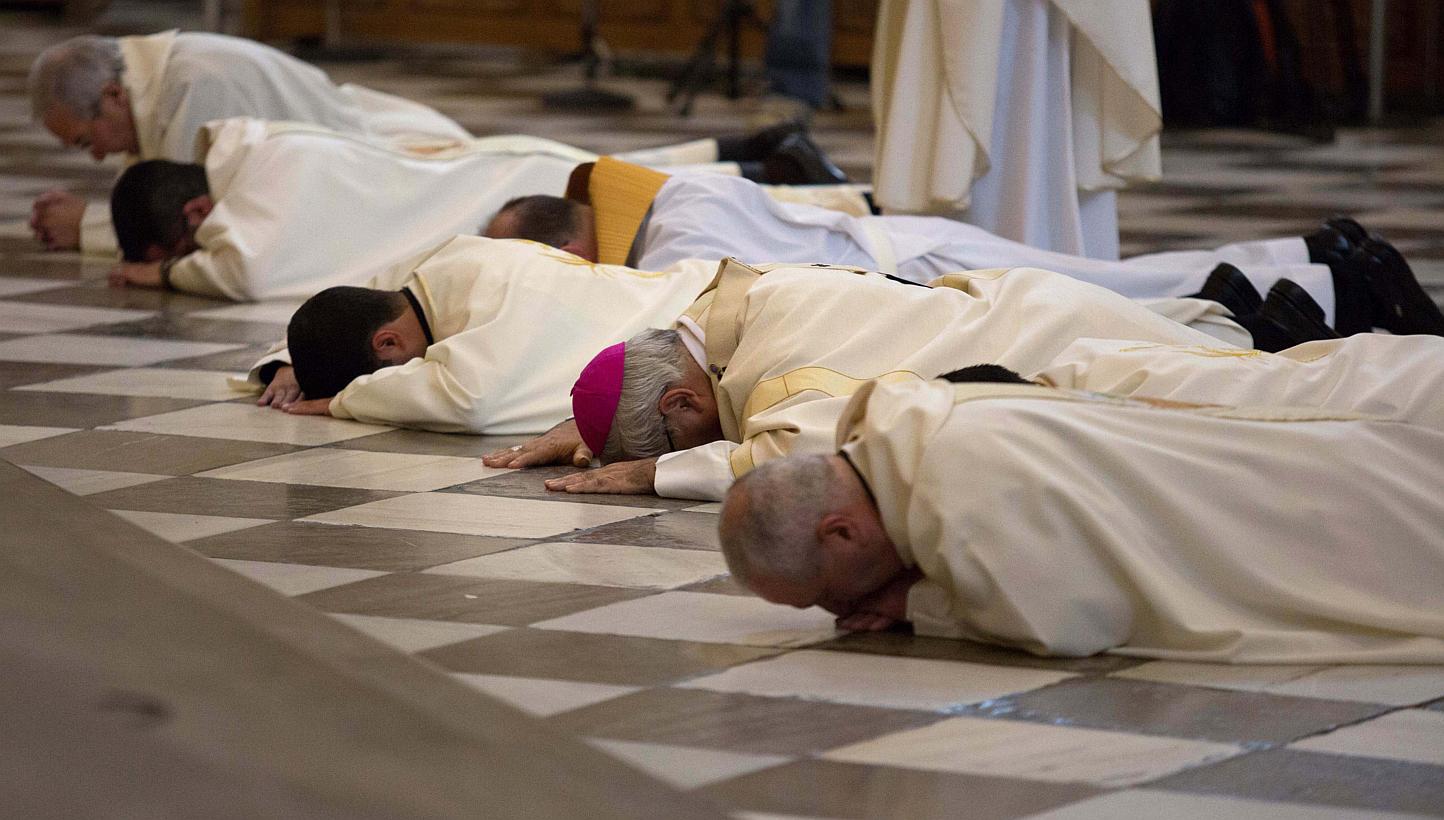 Archbishop of Granada Francisco Javier Martinez and priests prostrate in front of the altar to seek pardon for sexual abuse in the Church at the cathedral in Granada, southern Spain on November 23, 2014. PHOTO: REUTERS