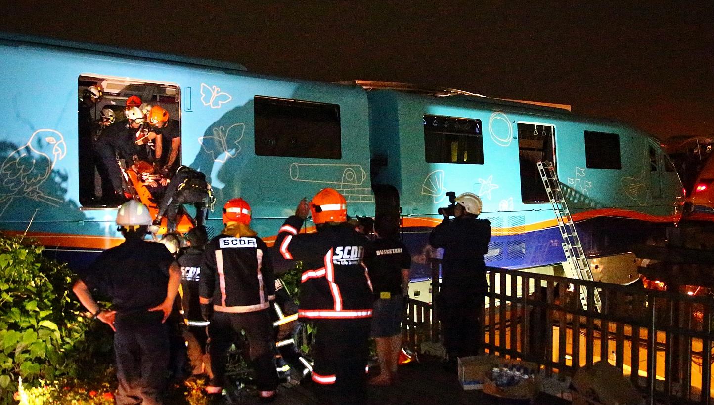 Singapore Civil Defence Force (SCDF) officers evacuating passengers who were stuck on the monorail. -- PHOTO: THE NEW PAPER FILE