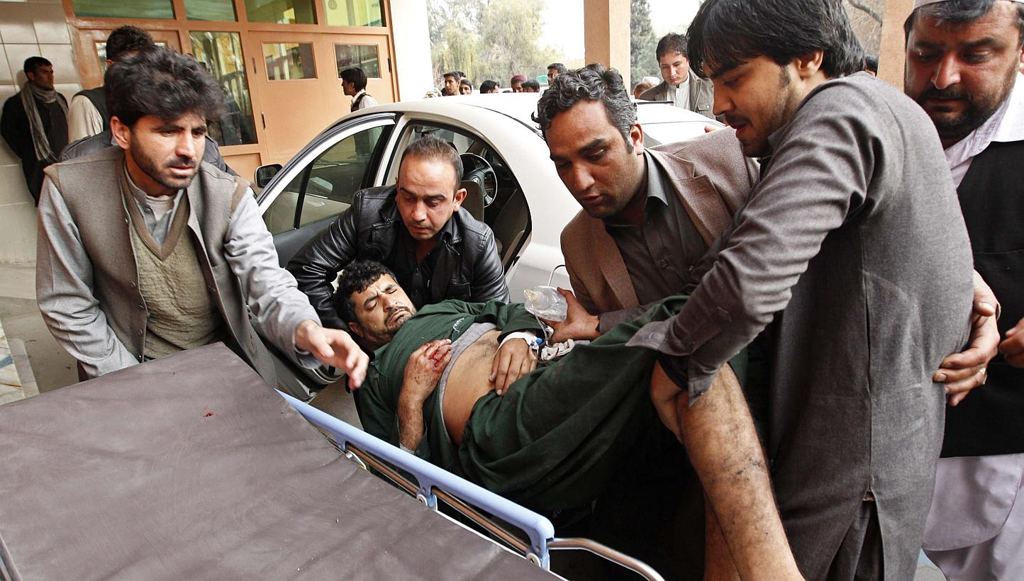 Afghan men carry a wounded man at a hospital in Jalalabad, after a suicide attack which targeted funeral prayers in Laghman province, Jan 29, 2015. -- PHOTO: REUTERS