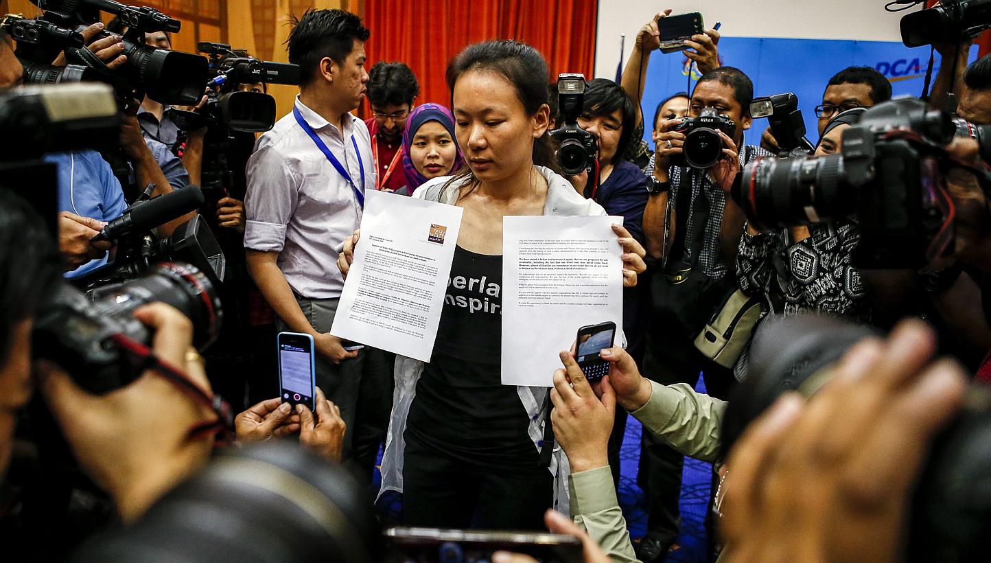 The wife of a missing Malaysia Airlines Flight MH370 passenger shows a press statement to reporters at a media conference room in Putrajaya, Malaysia, on Jan 29, 2015. -- PHOTO: EPA&nbsp;