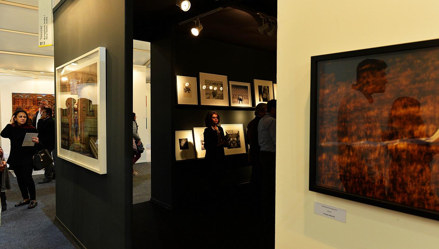 In this photograph taken on Jan 29, 2015 visitors walk through the exhibits during the India Art Fair in New Delhi. With a giant stainless steel elephant, a graffiti mural and a dying tree branch, the Indian Art Fair opened Friday hoping to tap