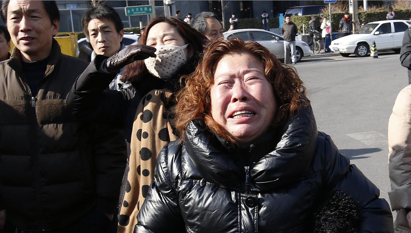 A family member of a passenger onboard the missing Malaysia Airlines flight MH370, cries during a protest demanding the Malaysian government to keep searching the missing flight, in front of the Malaysian Embassy in Beijing on Jan 29, 2015. -- PHOTO: