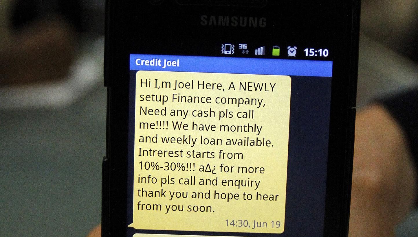A text message of a loan scam shown on a mobile phone. -- PHOTO: LIANHE ZAOBAO