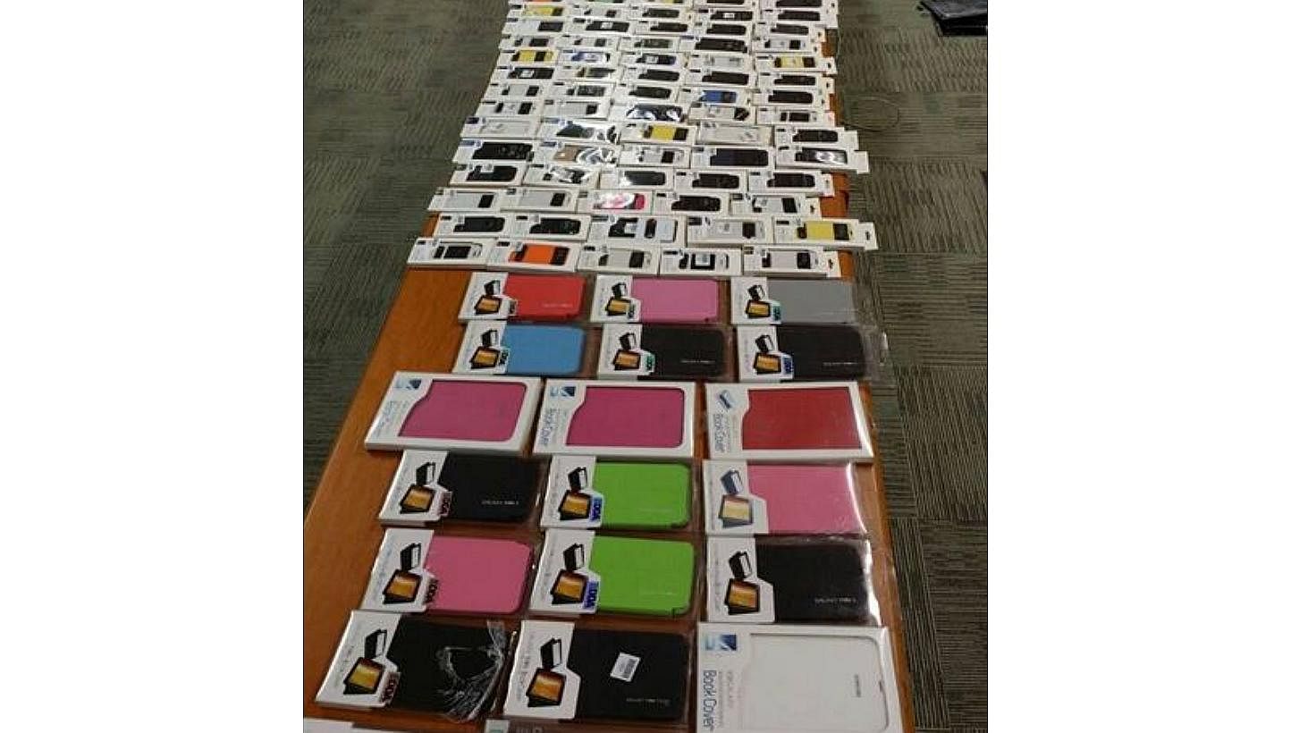 Police arrested 11 men and seized 12,900 counterfeit mobile phones and accessories worth $600,000, after a raid on 16 shops in Little India on Wednesday. -- PHOTO: SINGAPORE POLICE FORCE