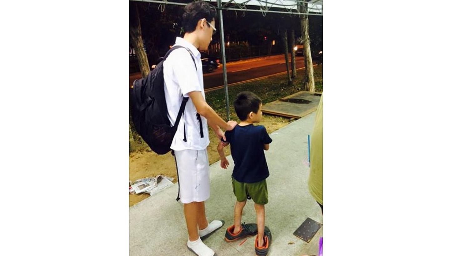Facebook user Zen Ginji on Wednesday posted a photo of the boy in oversized shoes with a caption commending the student. He said the student is from Edgefield Secondary School in Punggol. -- PHOTO: ZEN GINJI/FACEBOOK