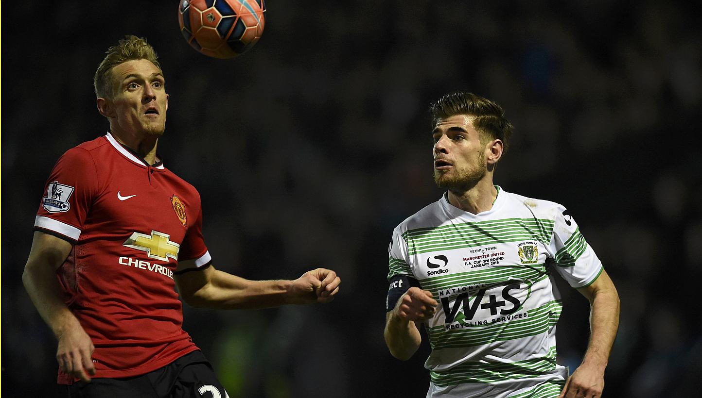 Darren Fletcher of Manchester United (left) and Joseph Edwards of Yeovil chase the ball during their FA Cup third round soccer match at Huish Park, Yeovil, western England, Jan 4, 2015. -- PHOTO: REUTERS