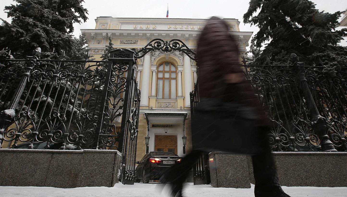 A pedestrian walks past the Central Bank headquarters in Moscow on Jan 30, 2015. Russia's central bank cut its key interest rate by two points to 15 percent on Friday, as the economy slides toward recession because of a collapse in global oil prices