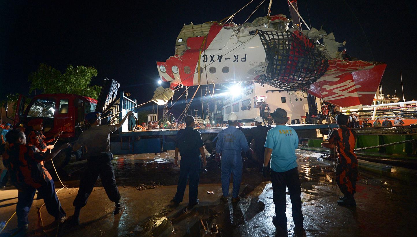The tail section of the Air Asia Airbus A320 flight QZ8501 being prepared for loading onto a truck at port in Kumai on Jan 11, 2015. -- PHOTO: AFP