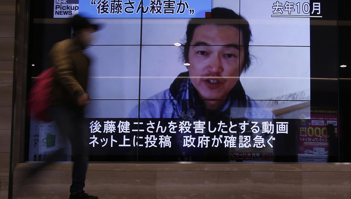 A pedestrian walks past television screens displaying a news programme about Japanese journalist Kenji Goto, who was a hostage of Islamic State in Iraq and Syria (ISIS) militants, on a street in Tokyo, on Feb 1, 2015. Singapore strongly condemns