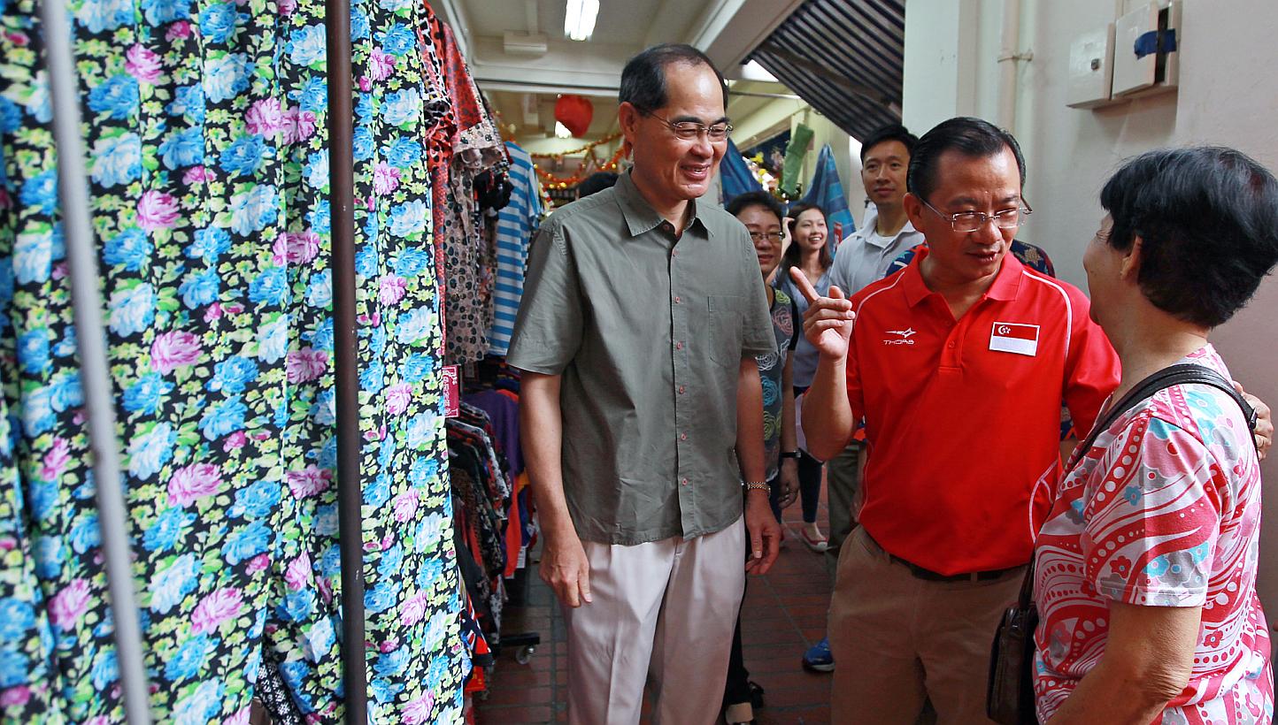 Minister for Trade and Industry Lim Hng Kiang (left) and&nbsp;Marine Parade GRC MP Seah Kian Peng (in red) speaking to a resident during a visit to Braddell Heights on Feb 1, 2015. -- PHOTO:&nbsp;LIANHE ZAOBAO&nbsp;