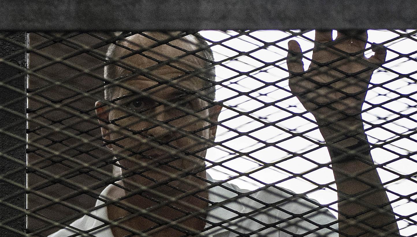 Al-Jazeera news channel's Australian journalist Peter Greste listening to the verdict inside the defendants cage during his trial for allegedly supporting the Muslim Brotherhood at the police institute near Cairo's Tora prison on June 23, 2014.