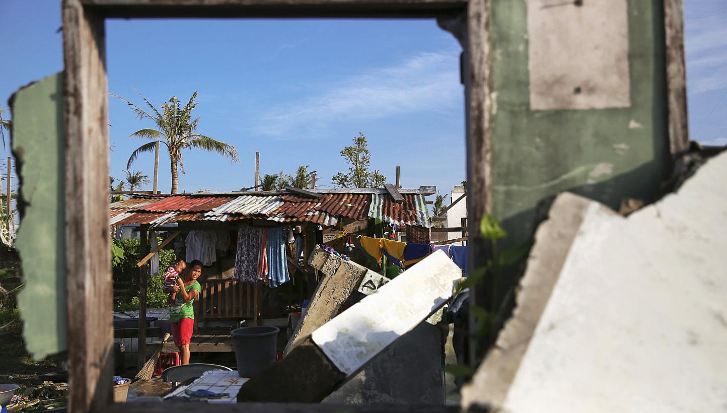 A resident of Tacloban walks with her child in part of the coastal area of the city that was destroyed by Typhoon Haiyan, on Jan 15, 2015. Australia is donating two decommissioned landing craft to the Philippine navy after the South-east Asian nation