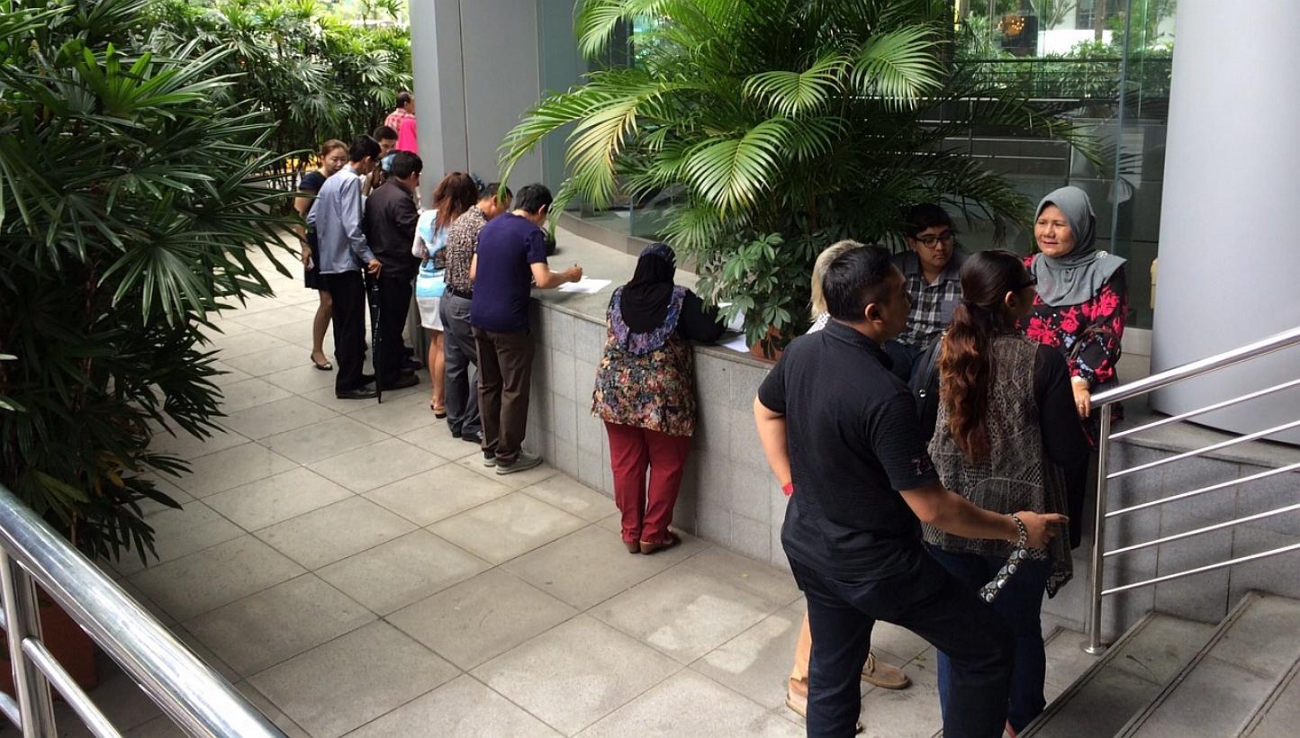 Investors who allegedly lost millions from Suisse International's gold buyback scheme outside the Commercial Affairs Department at Police Cantonment Complex on Feb 2, 2015. -- ST PHOTO: ONG WEE JIN