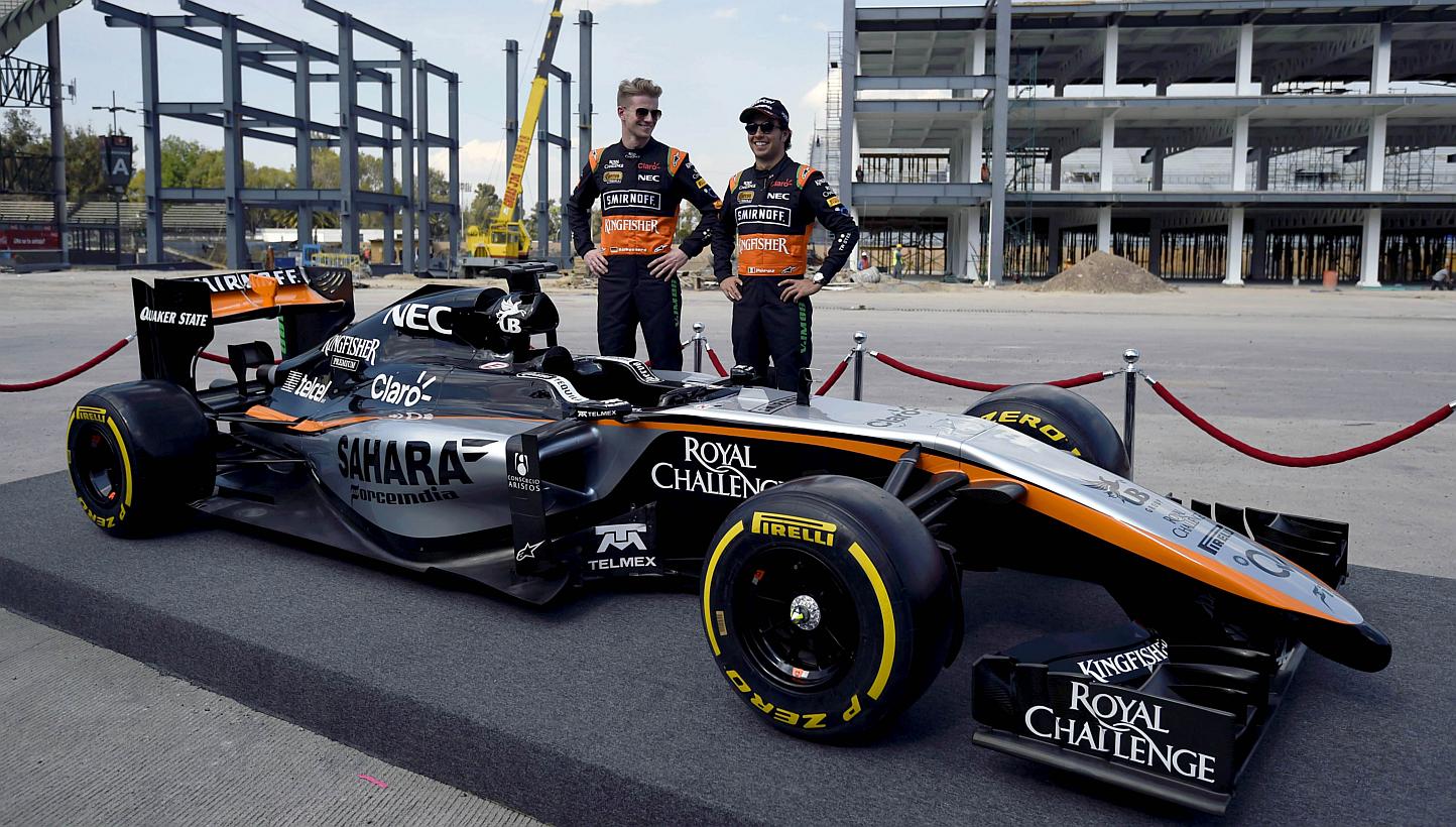 Force India drivers Nico Hulkenberg (left) of Germany and Sergio Perez of Mexico pose next to a Force India Formula 1 Team car with the new team livery that will adorn their cars on Jan 22, 2014. Force India have admitted their new VJM08 car may not 