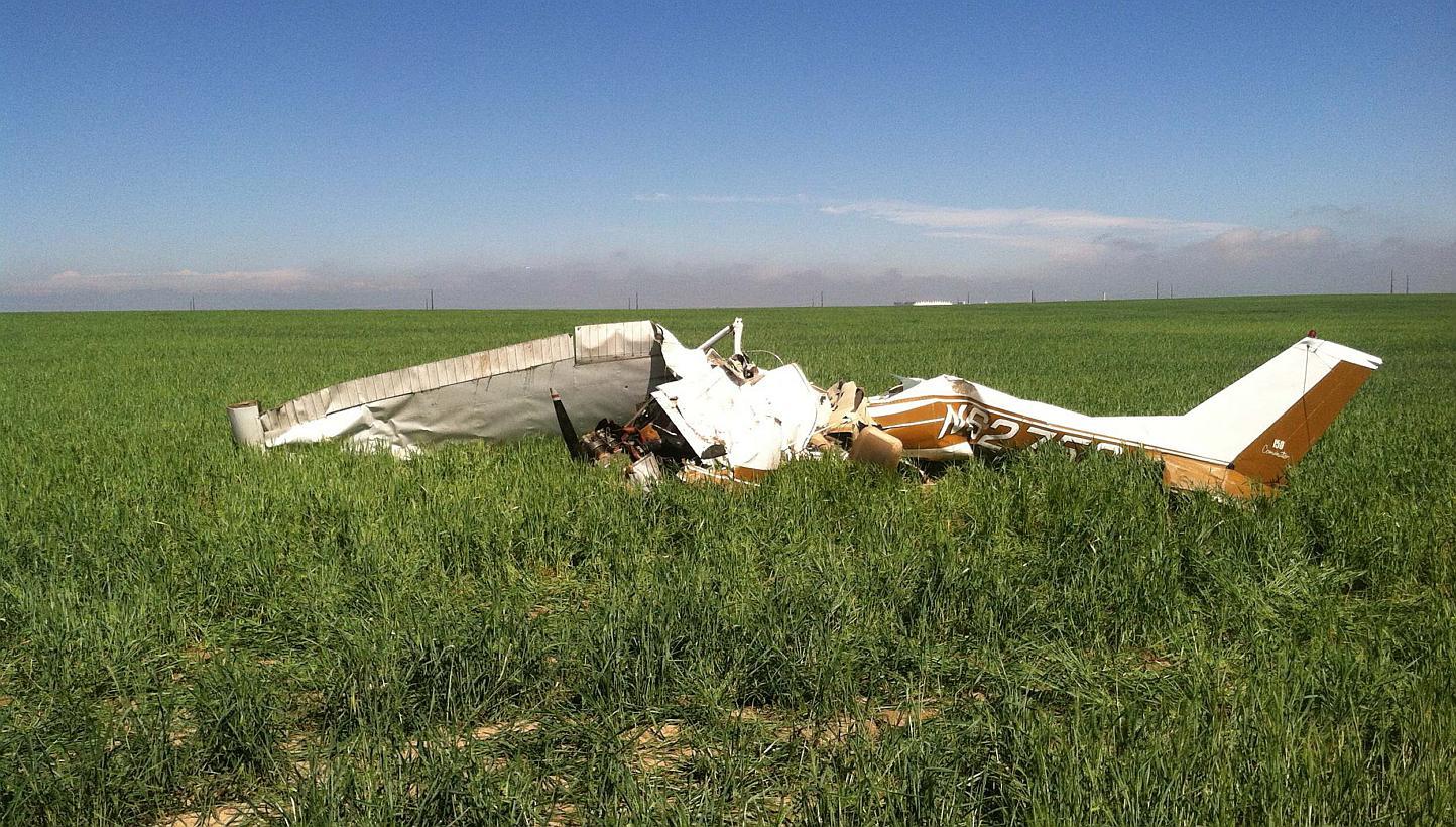 The wreckage of the crashed Cessna 150 airplane lying in a field near Watkins, Colorado on May 31, 2014. The pilot was taking selfie pictures with his phone before he crashed, killing himself and a passenger, investigators found. -- PHOTO: REUTERS