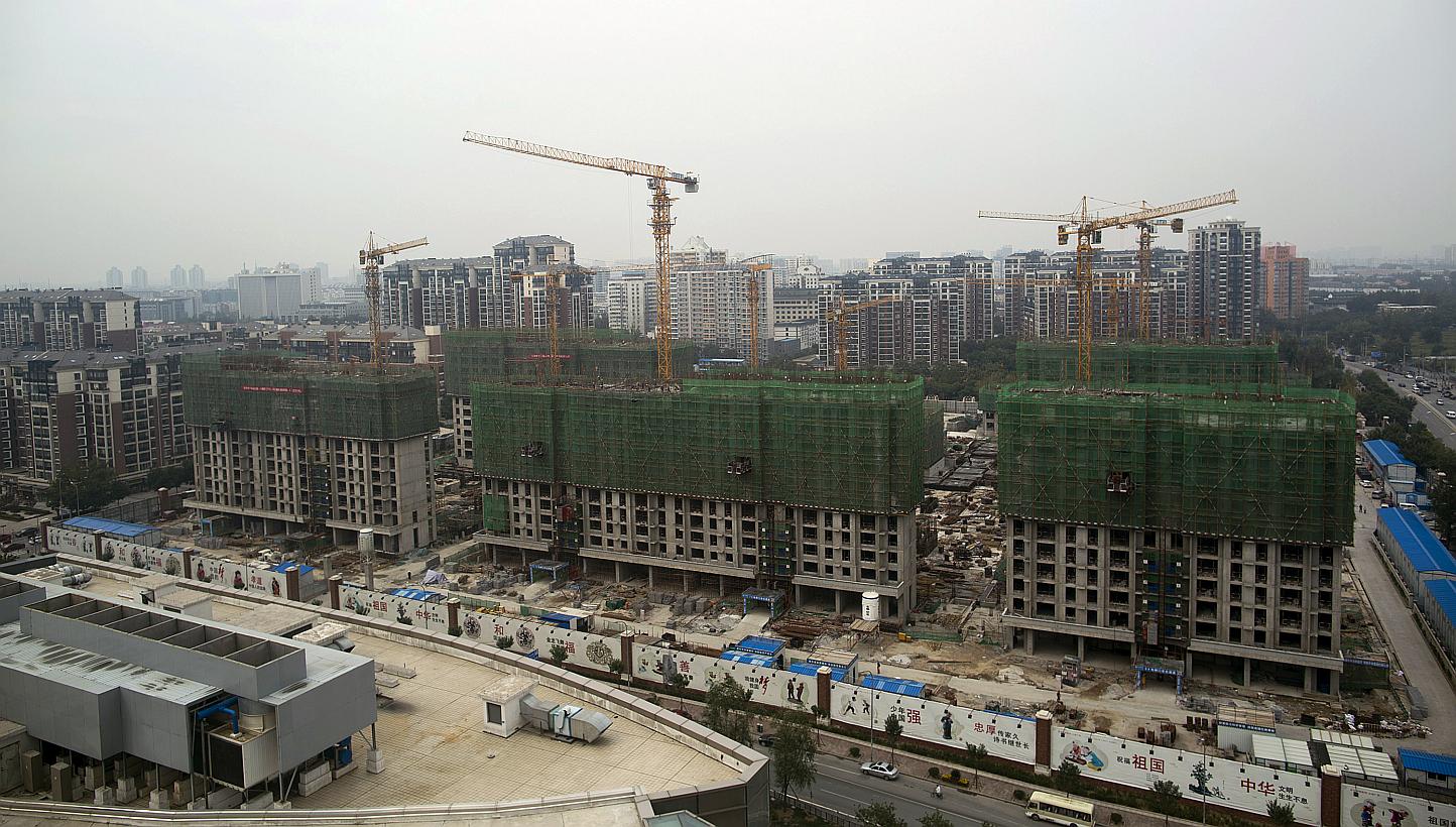 Cranes operating at a residential construction site in the Qinghe district of Beijing, China, on Friday, Sept 12, 2014. -- PHOTO: BLOOMBERG