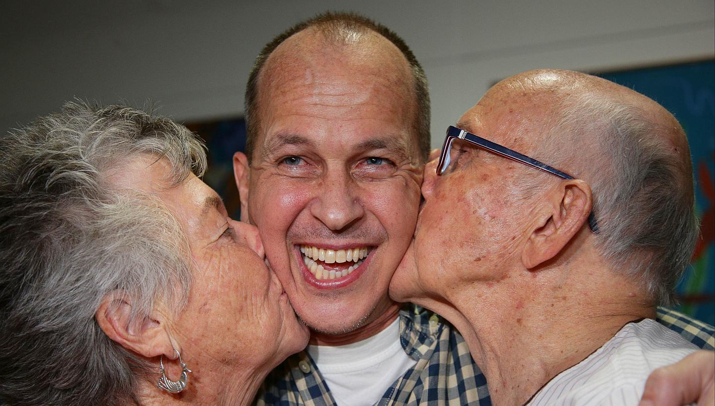 Al-Jazeera journalist Peter Greste is kissed by his mother Lois (left) and father Juris upon his arrival at Brisbane's international airport in the early hours of Feb 5, 2015. -- PHOTO: AFP