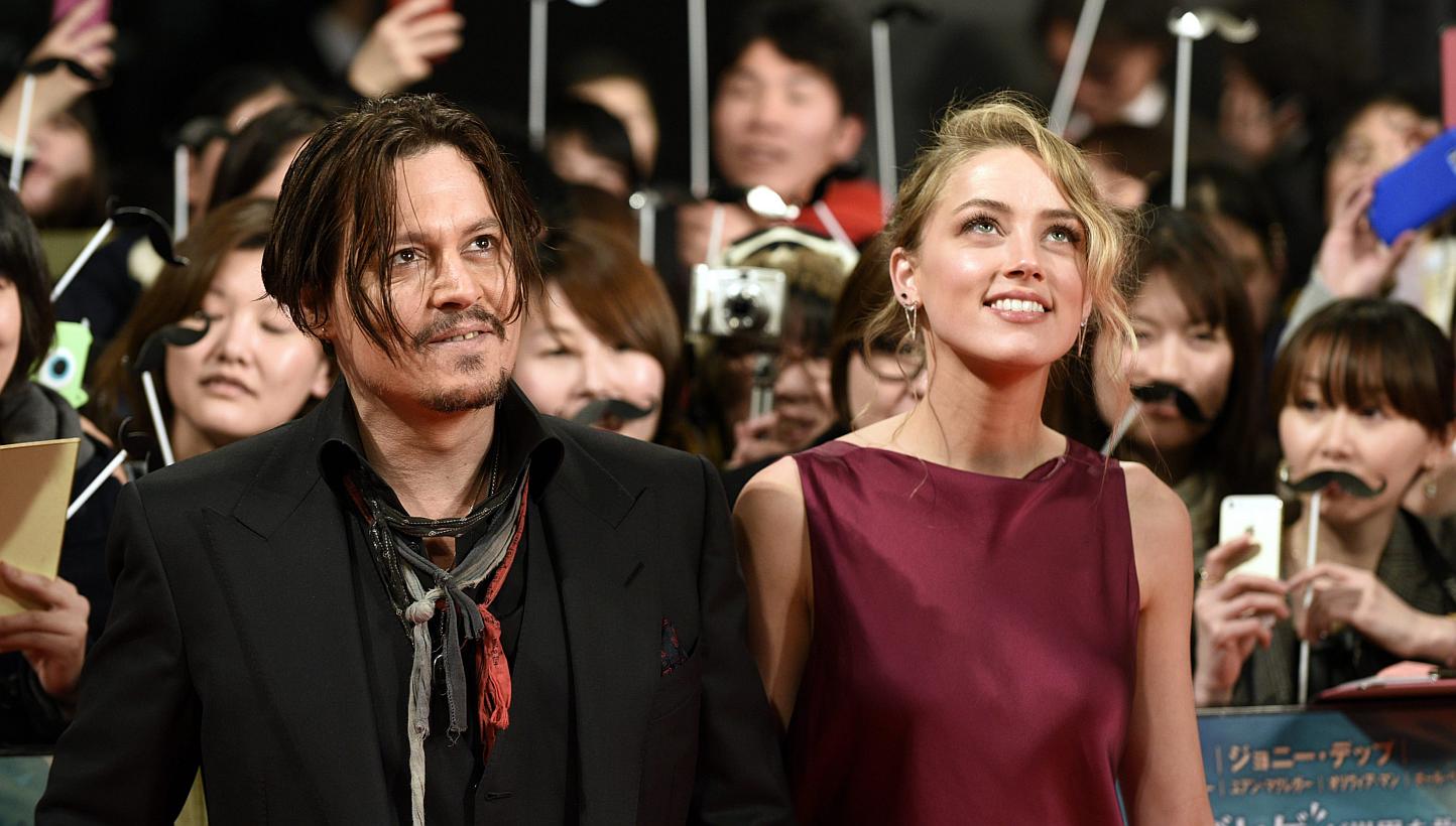 US actor Johnny Depp (left) and partner US actress Amber Heard arrive for the premiere of Mortdecai in Tokyo, Japan, on Jan 27, 2015. -- PHOTO: EPA