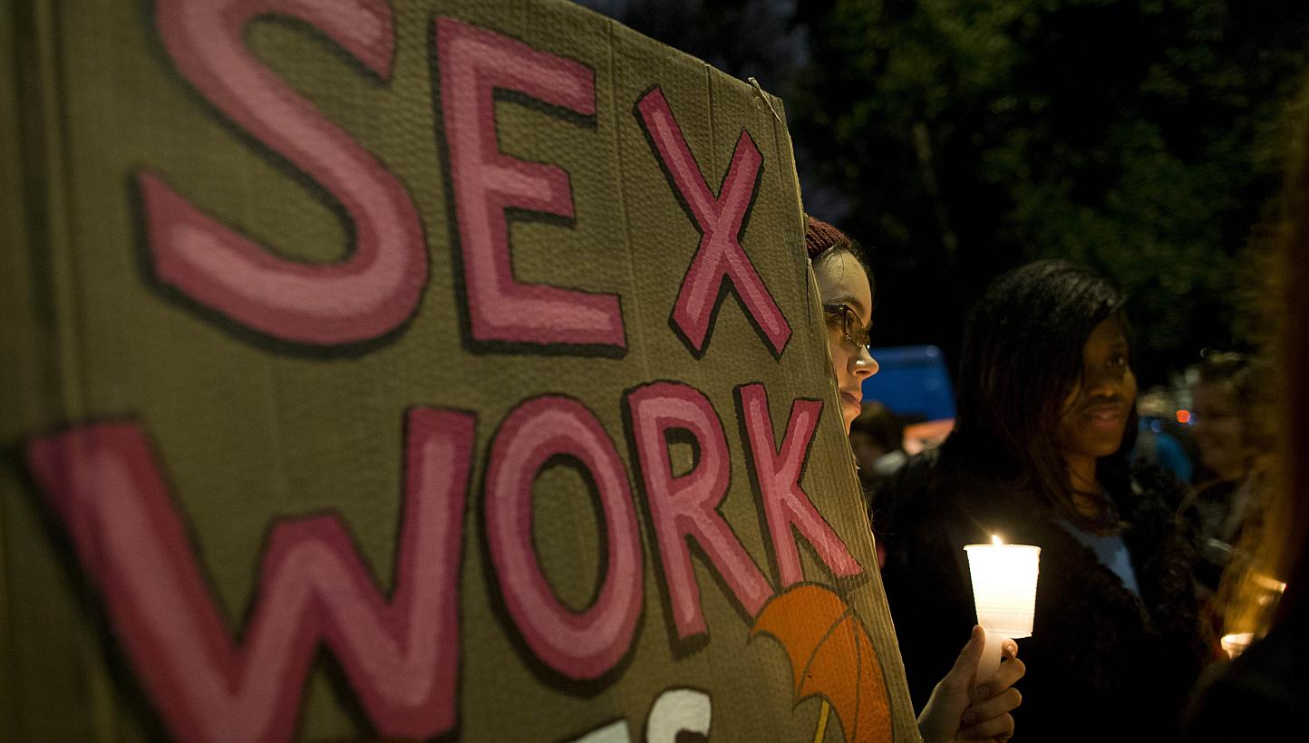 A protester holds a placard during a candlelight vigil to mark the international day to end violence against sex workers in London on Dec 17, 2014. Amsterdam is looking for an investor to buy five buildings where sex workers can work collectively in