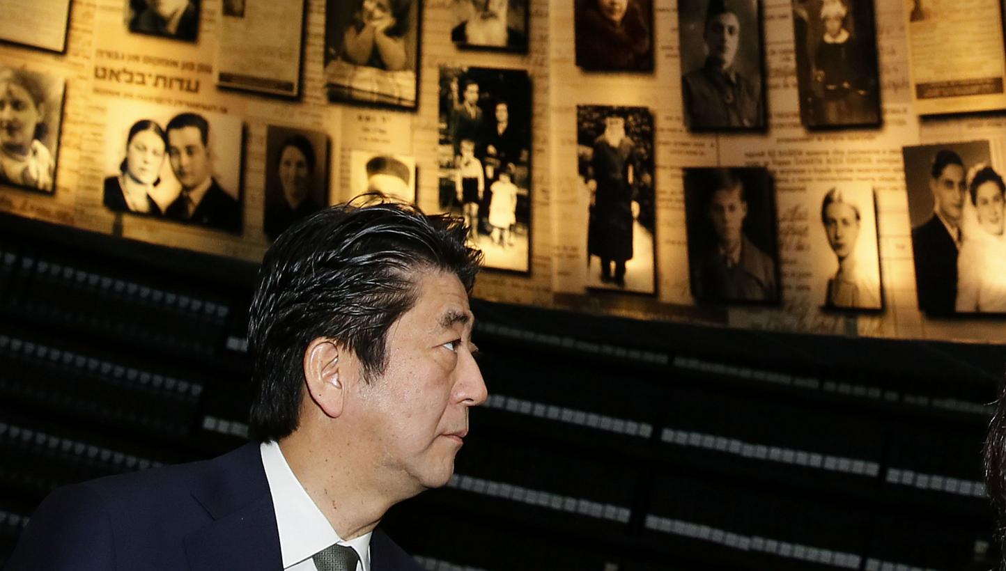 Japanese Prime Minister Shinzo Abe and his wife Akie look at pictures of Jewish Holocaust victims at the Hall of Names on Jan 19, 2015 during their visit to the Yad Vashem Holocaust Memorial museum in Jerusalem commemorating the six million Jews kill
