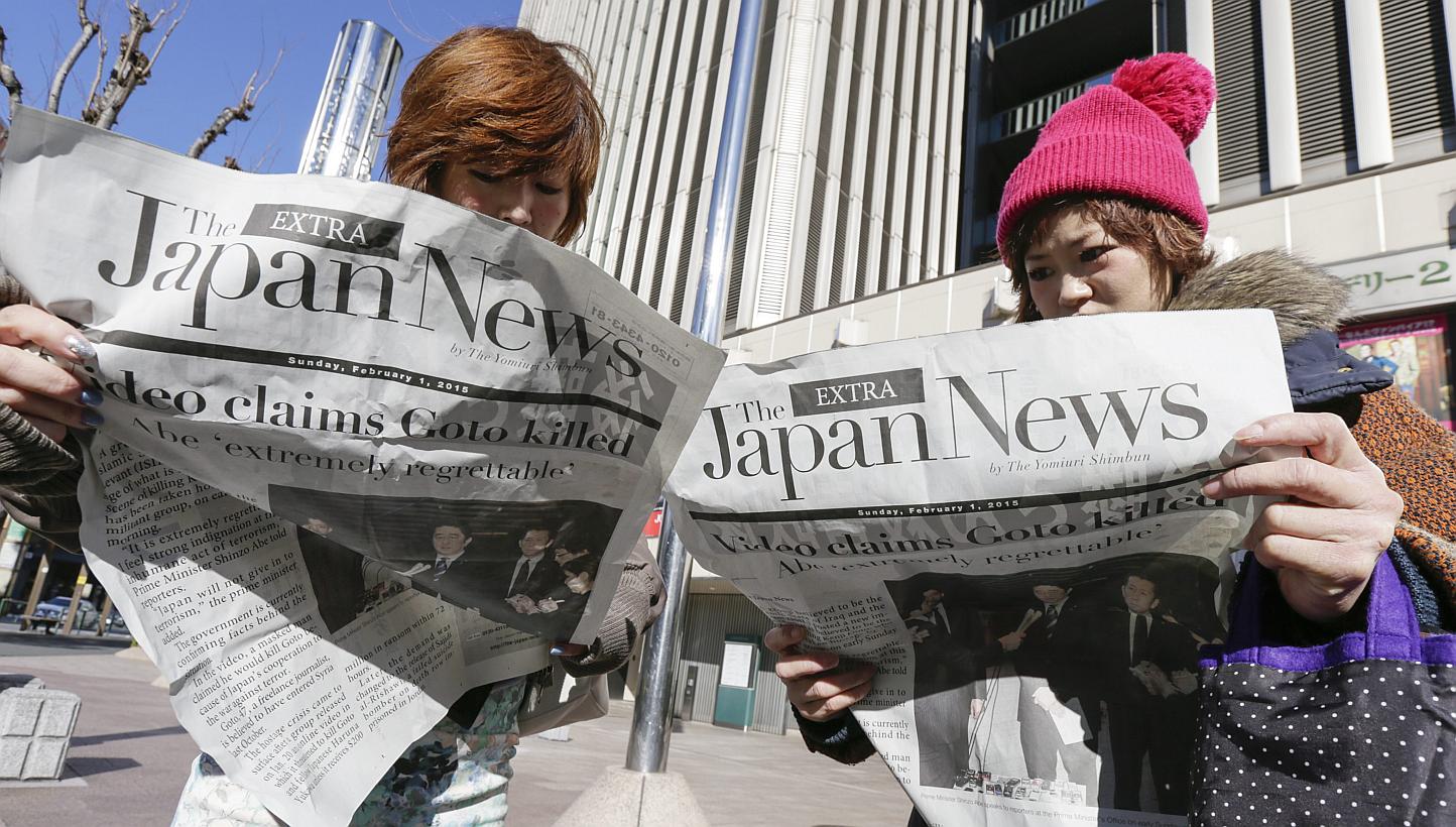 Japanese women read newspapers reporting about a video released online purportedly showing the execution of Japanese hostage kenji Goto by Islamic State in Iraq and Syria (ISIS) militants, in Tokyo, Japan on Feb 1, 2015. Japan has seized the pas