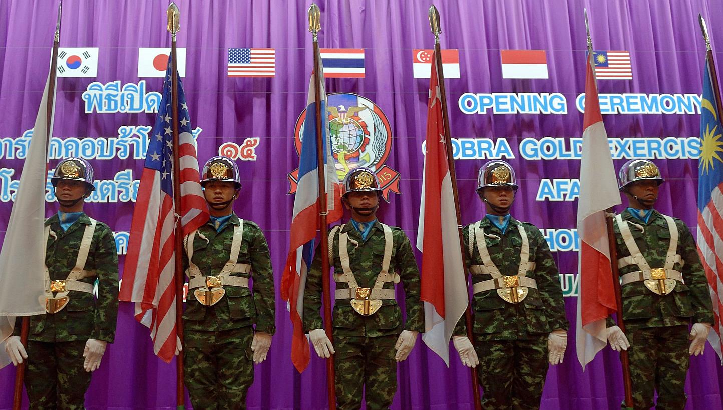 Thai soldiers carry national flags of the participating nations as they parade during the opening ceremony for the annual combined military exercises coined Cobra Gold 15 at Armed Forces Academies Preparatory School in Nakhon Nayok province on Feb 9,