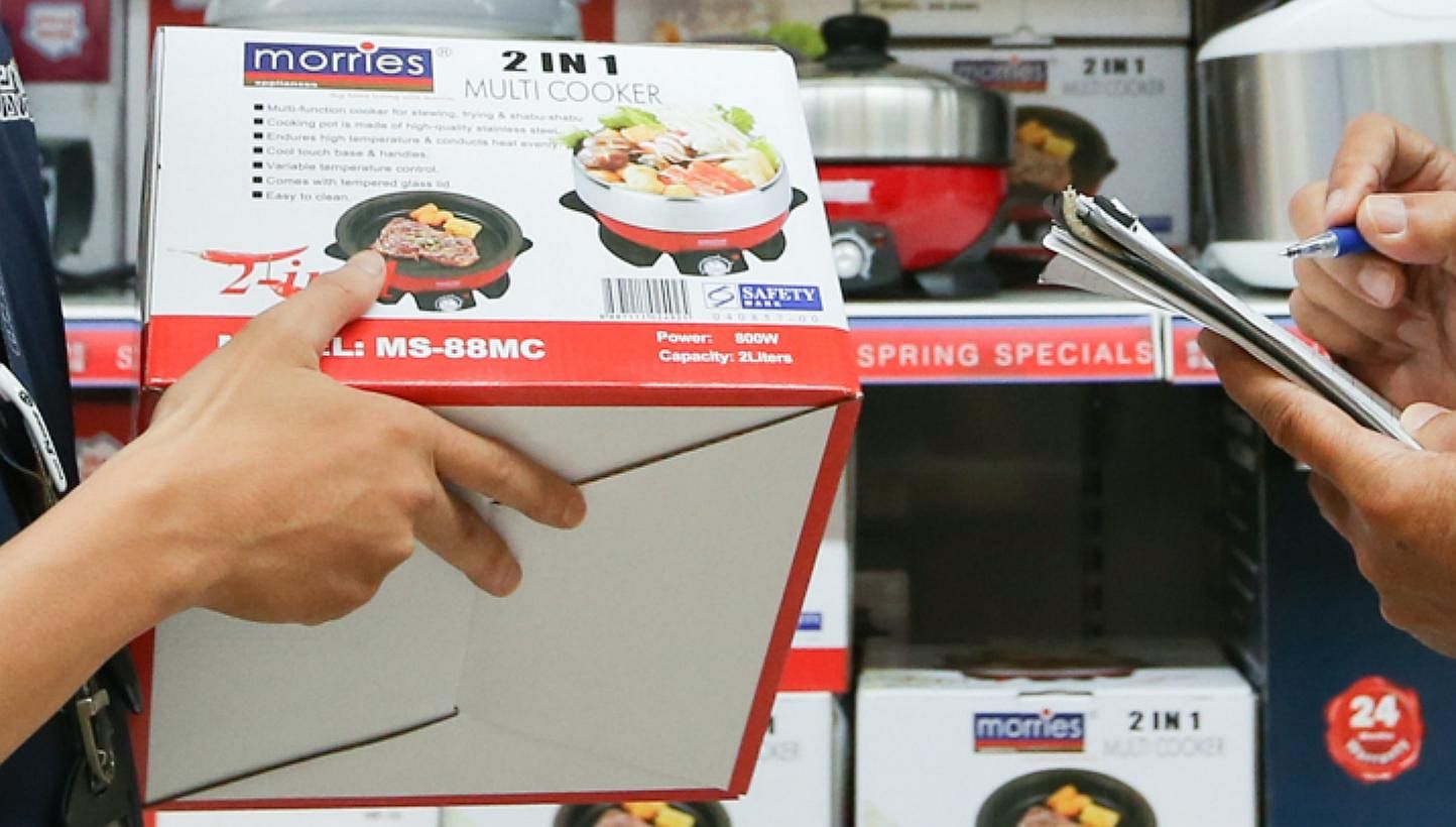 CERTIS Cisco enforcement officers checking for the Safety Mark sticker on electronic products sold in NTUC.&nbsp;Consumers who own electric bowls from the brands Nushi, T.M.D and T.A.C are advised to stop using them immediately if their appliances do