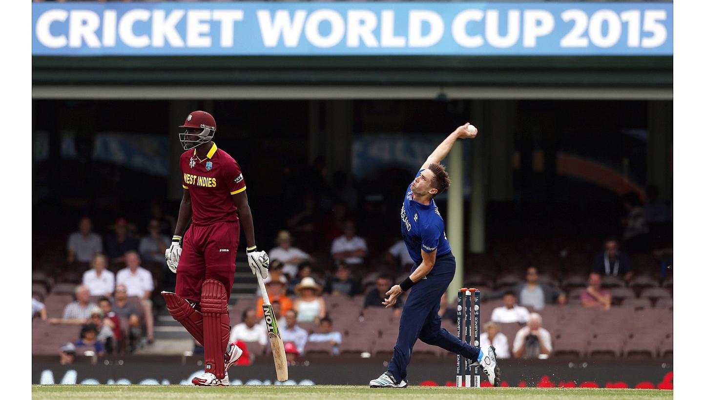 Chris Woakes (right) of England bowls next to Lendl Simmons of the West Indies during their warm-up match at the Sydney Cricket Ground on Feb 9, 2015. Chris Woakes took five for 19 as England claimed a comfortable nine-wicket victory in their fi