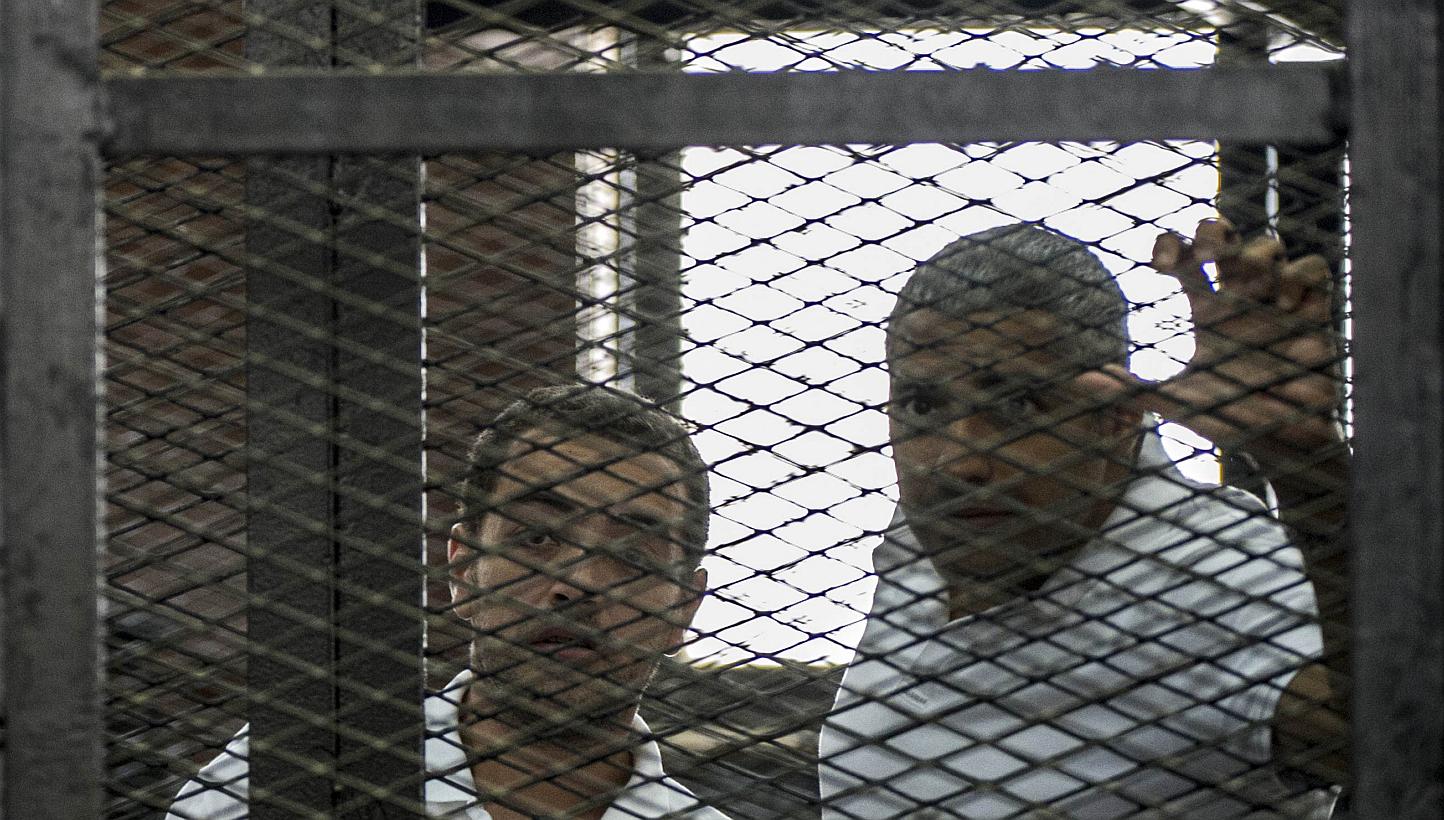 A file picture taken on Jun 23, 2014 shows Al-Jazeera news channel's journalists Egyptian-Canadian Mohamed Fahmy (right) and Egyptian Baher Mohamed (left) listening to the verdict inside the defendants cage during their trial for allegedly supporting