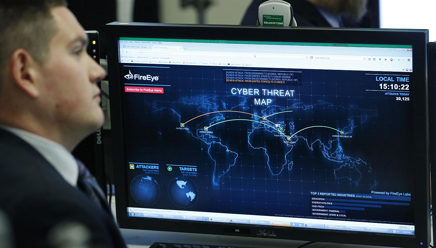 A Department of Homeland Security worker listening to US President Barack Obama talk at the National Cybersecurity and Communications Integration Centre (NCCIC) in Arlington, Virginia, on Jan 13, 2015. Two men wanted for cyber crimes by Interpol